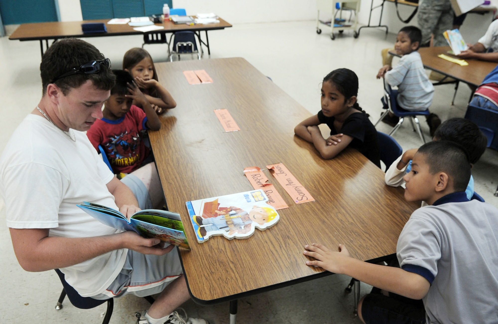 Airman 1st Class Justin Baker reads to kindergarten and first graders June 19 at Machananao Elementary School in Agana, Guam. The Chapel Hill, Tenn., native is deployed to Andersen Air Force Base, Guam, from Elmendorf AFB, Alaska, to support U.S. Pacific Command's continuous bomber presence in the Asia-Pacific Region. Airman Baker is a 3rd Expeditionary Maintenance Unit weapons load crew member. (U.S. Air Force photo/Senior Airman Christopher Bush)
