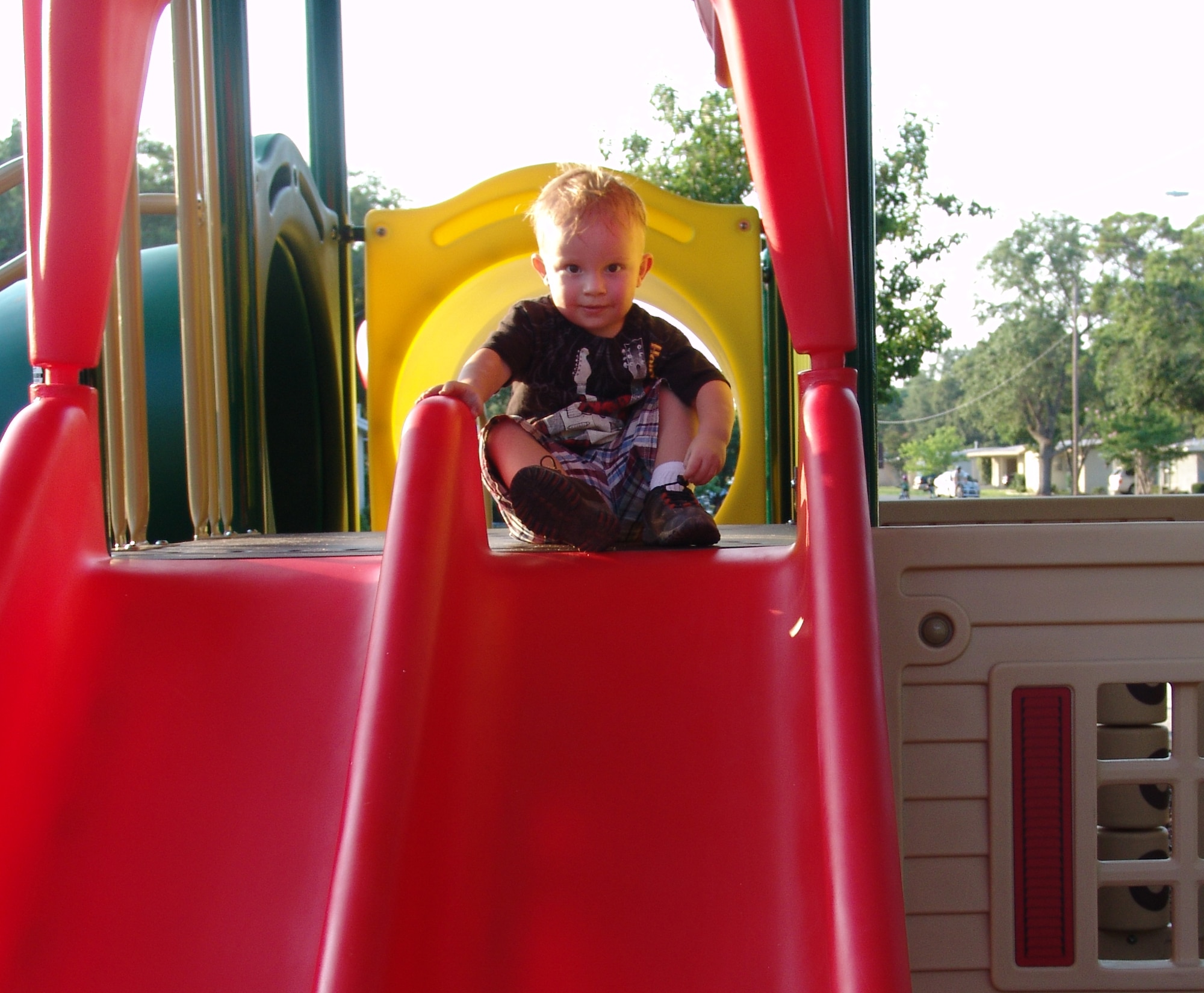 Donovan Malone is ready to go down one of the news slides at the playground on Chinquapin Drive.  Three new playgrounds are now open for children living in base housing. (USAF photo/Lois Walsh)                                                    