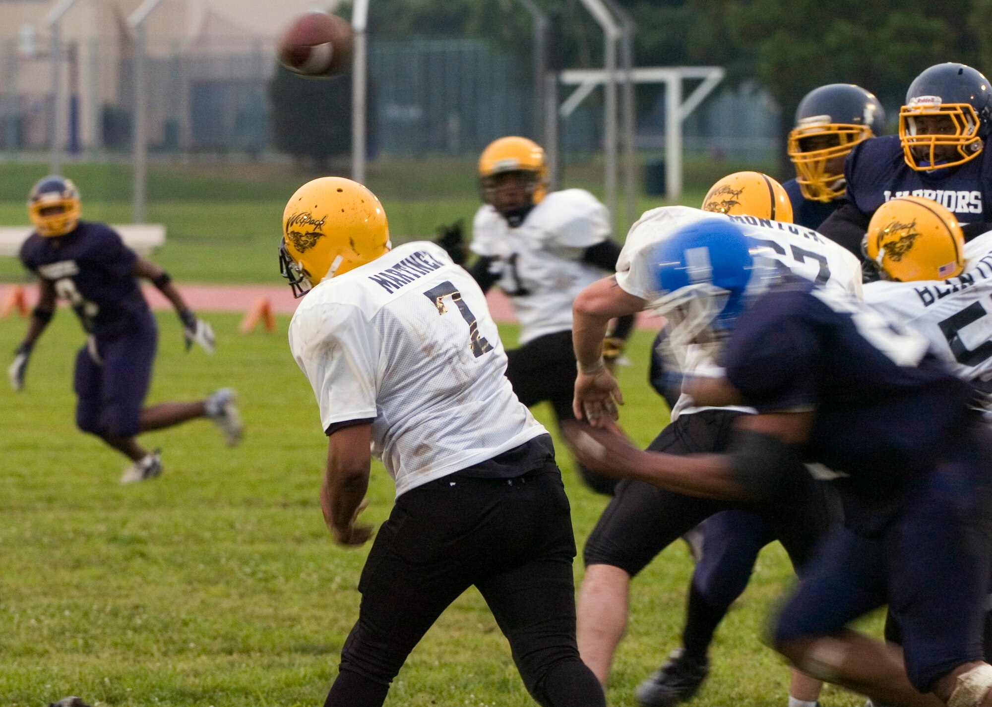 YOKOTA AIR BASE, Japan -- Torii Station's quarterback throws an incompletion just before taking a hit from Warriors' defensive end Dominique Carvin June 27 during Yokota's 12-6 win over the Wolfpack in U.S. Forces Japan-American Football League action at Bonk Field. Yokota improved to 2-3 on the season on the strength of a defense that has allowed only 18 points in the last two games. (U.S. Air Force photo/Master Sgt. Matt Summers)  