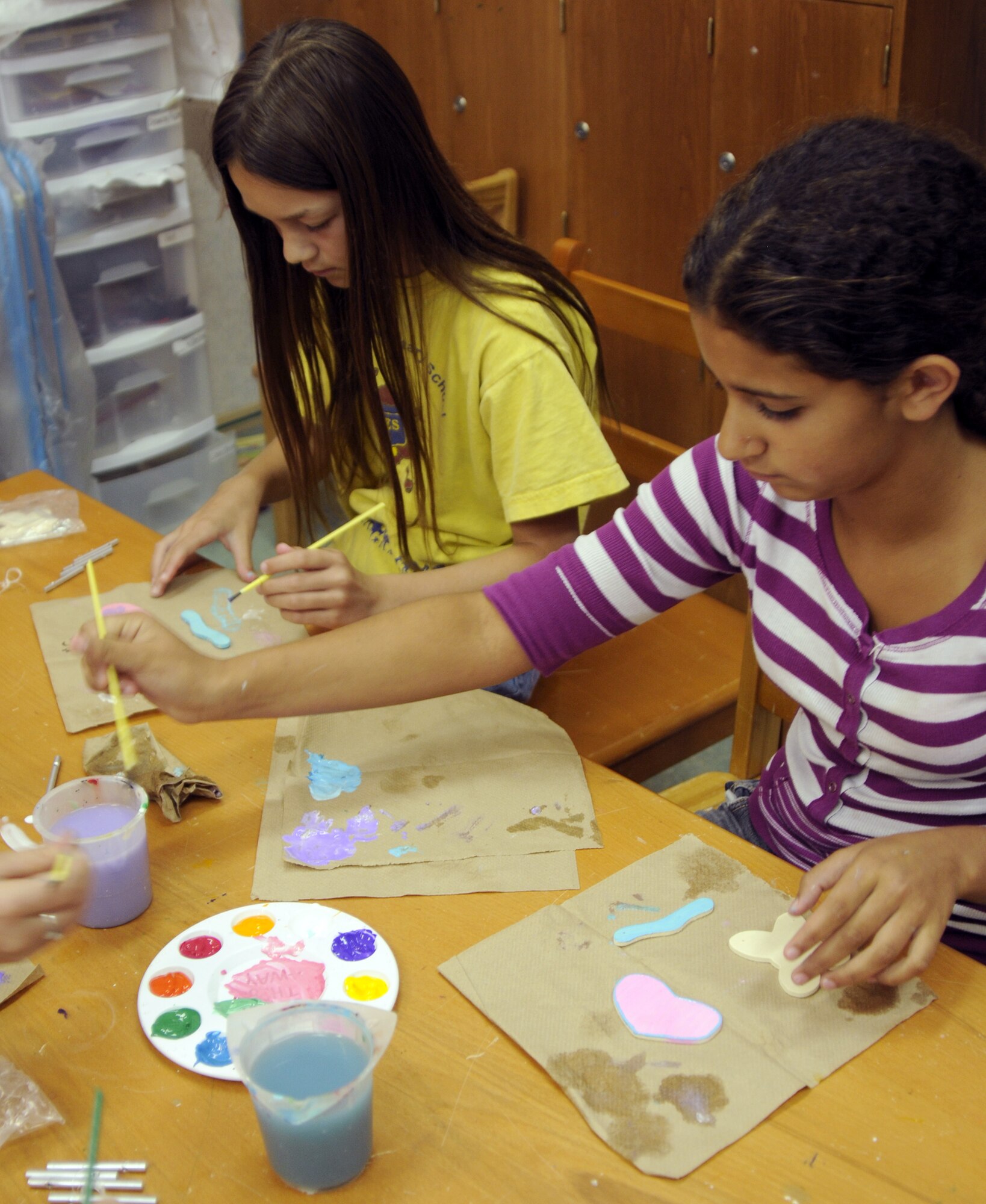 Maryn Carpenter, daughter of Capt. Michael Carpenter, 39th Medical Operations Squadron, and Oriana Suarez, daughter of Scott Welch, 39th Air Base Wing, paint wooden shapes for their handmade wind chimes Thursday, June 25, 2009 during the Youth Programs art camp at Incirlik Air Base, Turkey. The camp, which ran the entire week, is one of several camps and recreation trips available for children during their summer. For more information about activities call YP at 676-6670. (U.S. Air Force photo/Airman 1st Class Amber Russell)