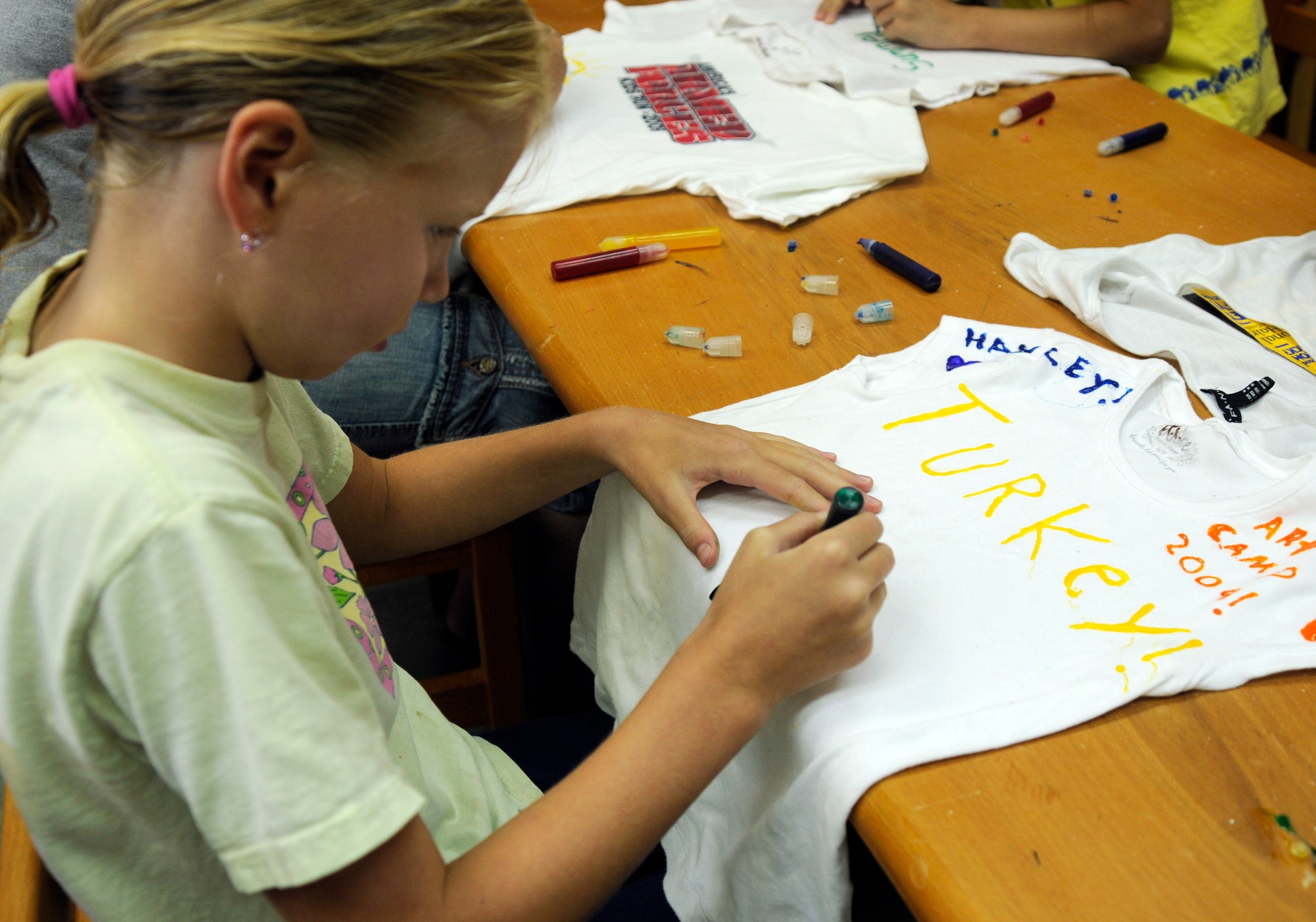 Hayley Turner, daughter of Maj. James Turner, 39th Force Support Squadron commander, stains her shirt with tubed ink Thursday, June 25, 2009 during the Youth Programs art camp at Incirlik Air Base, Turkey. The camp, which ran the entire week, is one of several camps and recreation trips available for children during their summer. For more information about activities call YP at 676-6670. (U.S. Air Force photo/Airman 1st Class Amber Russell)