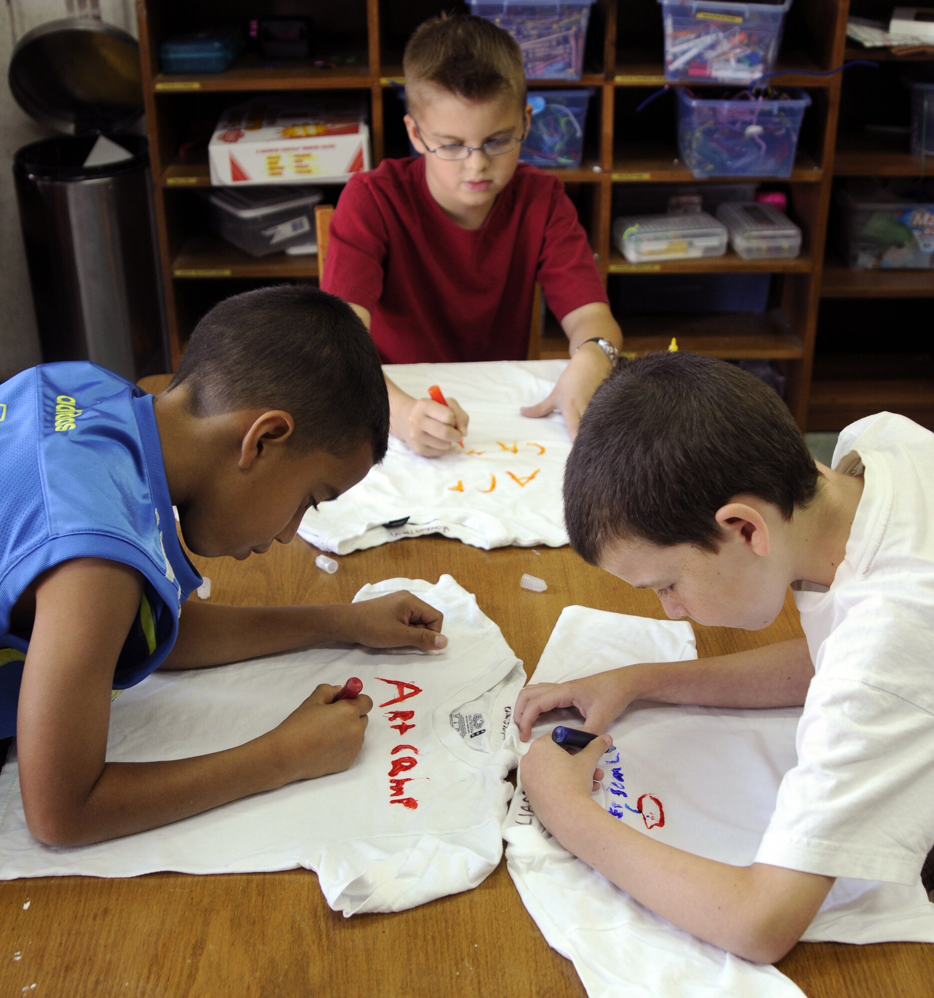 (Left to right) Christopher Montalvo, son of Senior Airman Yahood Montalvo, 39th Communications Squadron, Jonathan Gunter, son of Master Sgt. Tony Gunter, 39th Operations Squadron, and Liam McCammon, son of Capt. Shane McCammon, 39th Air Base Wing, share tubed ink to stain their shirts Thursday, June 25, 2009 during the Youth Programs art camp at Incirlik Air Base, Turkey. The camp, which ran the entire week, is one of several camps and recreation trips available for children during their summer. For more information about activities call YP at 676-6670. (U.S. Air Force photo/Airman 1st Class Amber Russell)