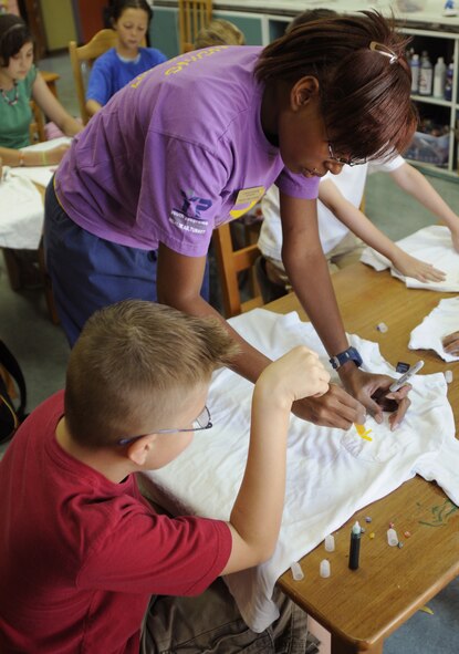 LaVonna Walker, Youth Programs assistant, shows Jonathan Gunter, son of Master Sgt. Tony Gunter, 39th Operations Squadron, how to use tubed ink to stain his t-shirt Thursday, June 25, 2009 during a YP art camp at Incirlik Air Base, Turkey. The camp, which ran the entire week, is one of several camps and recreation trips available for children during their summer. For more information about activities call YP at 676-6670. (U.S. Air Force photo/Airman 1st Class Amber Russell)