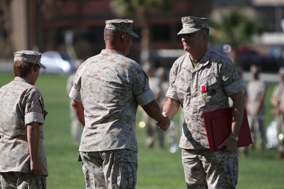 Brig. Gen. Charles M. Gurganus, the Combat Center's commanding general, shakes the hand of Col. David N. Gill, the former branch head and officer-in-charge of the Individual Mobilization Augment Detachment, Career Management Team, Reserve Affairs, Manpower and Reserve Affairs, Headquarters Marine Corps, after being presented the Legion of Merit during his retirement ceremony at the Combat Center's Lance Cpl. Torrey L. Gray Field June 30.