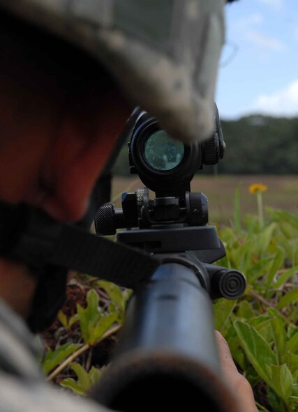 WHEELER ARMY AIR FIELD, Hawaii -- Airman 1st Class Doug Fraites, 25th Air Support Operations Squadron ground radio maintenance, secures a perimeter for a landing zone at Wheeler Army Air Field's East Range near Hickam AFB June 24. Training included combat lifesaver skills, convoys, air assault egression, and improvised explosive device reaction and will give Tactical Air Control Party members a better idea of what to expect when they deploy to Afghanistan with an Army unit. (U.S. Air Force photo/Senior Airman Carolyn Viss)