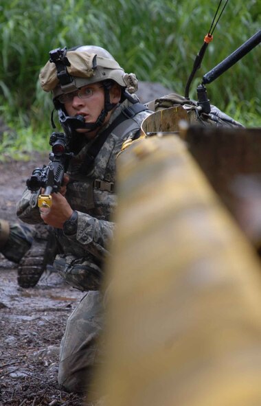 WHEELER ARMY AIR FIELD, Hawaii -- Airman 1st Class Chris Tamblyn, 25th Air Support Operations Squadron Tactical Air Control Party, provides small arms fire cover for members of his unit who were evading opposing forces during a field training exercise here June 23. Armed with M-16s and basic radio and global positioning system equipment, they made their way through wet brush to find their camping spot and were "ambushed" along the way by pseudo attackers. Training like this ensures safe and reliable wartime readiness for TACPs. (U.S. Air Force photo/Senior Airman Carolyn Viss)