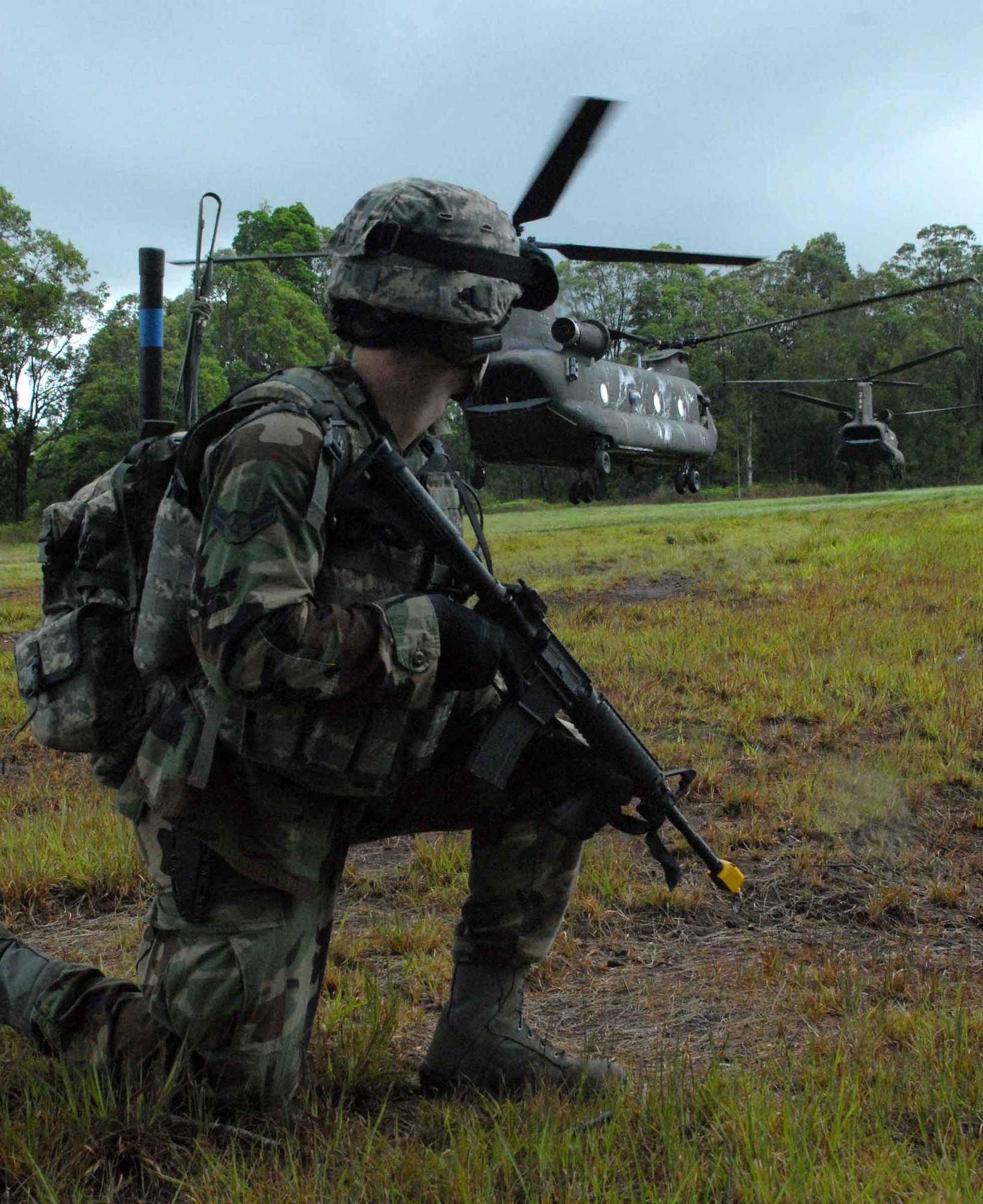 WHEELER ARMY AIR FIELD, Hawaii -- A 25th Air Support Operations Squadron Tactical Air Control Party Airman provides landing zone security for an Army National Guard CH-47 Chinook on Wheeler Army Air Field's East Range June 23. He and other Radio Operators, Maintainers and Drivers camped out for four days to sharpen proficiencies necessary for upgrade training to become combat mission-ready Joint Terminal Attack Controllers. Because they're training now, they'll have a better idea of what to expect when they get to Afghanistan with an Army unit. (U.S. Air Force photo/Senior Airman Carolyn Viss)