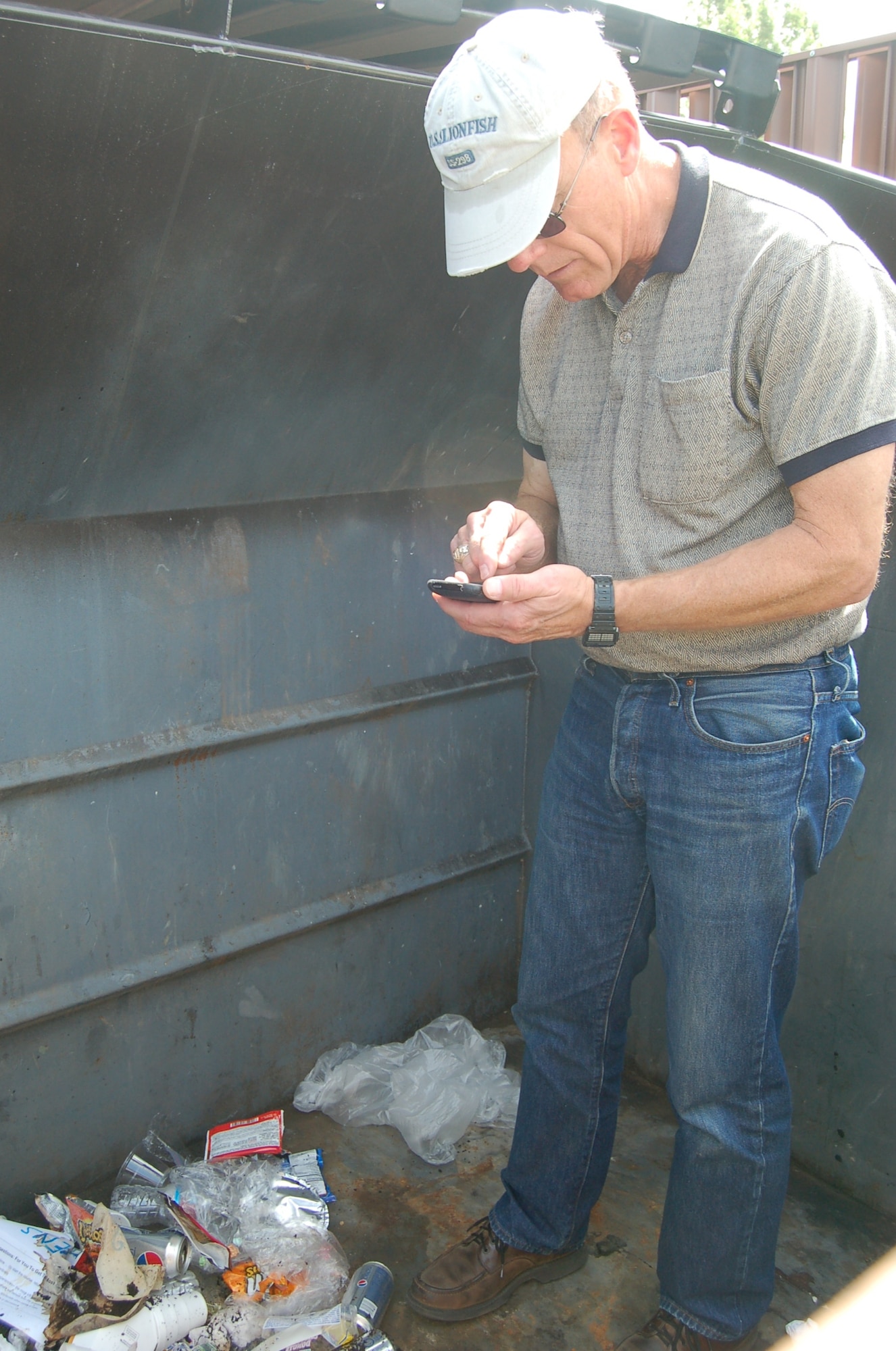 Jerry Lowder, 21st Space Wing Civil Engineer Squadron Natural Assets Flight Environmental Program manager, counts recyclable containers found inside a trash dumpster at Peterson Air Force Base June 24. Mr. Lowder acted as a solid waste assessor during the wing’s Environment, Safety, and Occupational Health Com pliance Assessment and Management Program, also known as ESOHCAMP. The annual self-assessment of environmental practices occurred at Peterson June 22 through June 26 and checked unit compliance of Air Force, state, and federal regulations. Mr. Lowder found 13 aluminum cans, required by regulation to be placed in recyclable dumpster, in the trash dumpster.  (Air Force photo by Thea Skinner)  
