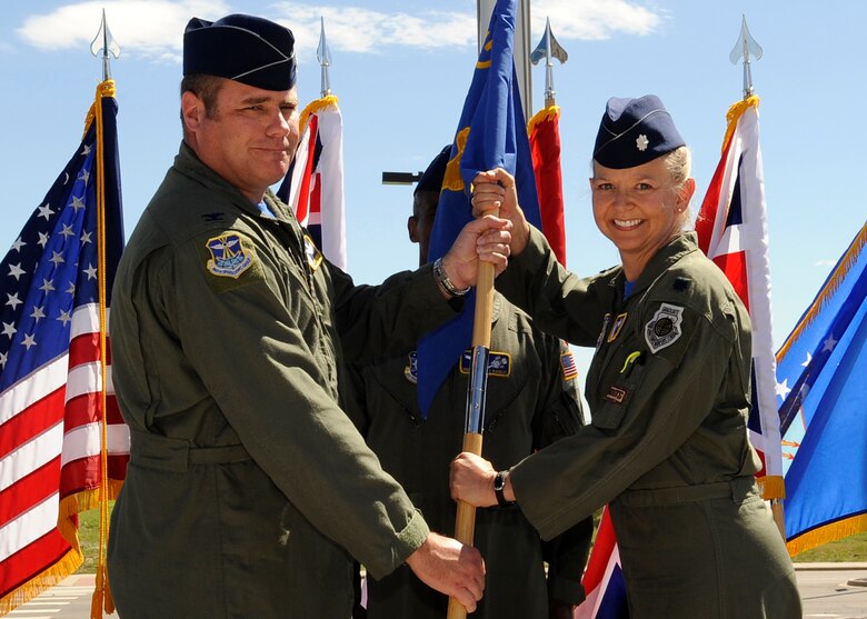 Col. Richard Schoonmaker, 460th Operations Group commander, passes command of the 2nd Space Warning Squadron over to incoming commander Lt. Col. Jennifer Jenkins here, June 26. (U.S, Air Force photo by: Senior Airman Steven Czyz)
