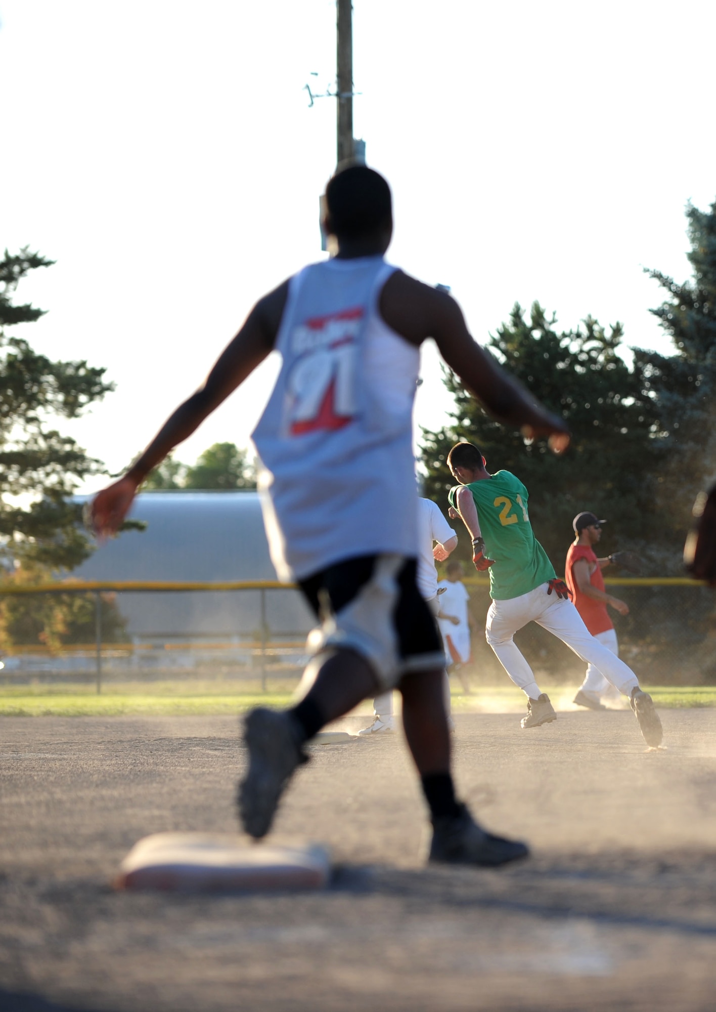 MOUNTAIN HOME AIR FORCE BASE, Idaho -- Left, Renishia Richardson, 366th Security Forces Squadron second baseman rounds first base after hitting a shot to right center field as John Sloan, 366th SFS shortstop, heads to third base during the SFS versus 366th Force Support Squadron intramural softball game June 24. SFS demolished FSS 22-8. (U.S. Air Force photo/Senior Airman Samantha S. Crane)