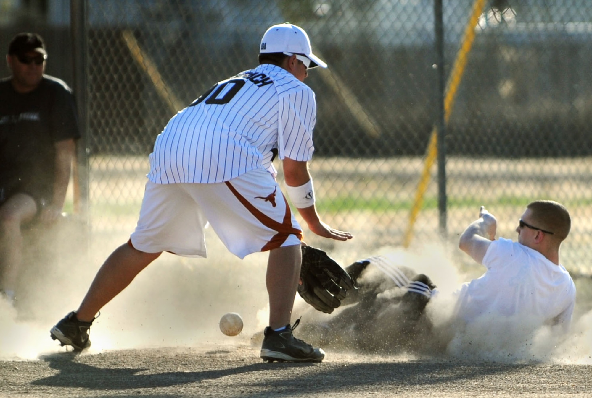 MOUNTAIN HOME AIR FORCE BASE, Idaho -- Brett Reynolds, 366th Operations Support Squadron right fielder, slides safely into third base while Cory Rohrenbach, 366th Maintenance Operations Squadron third baseman, fumbles with the ball during the OSS versus MOS intramural softball game June 24. OSS smashed MOS 17-7. (U.S. Air Force photo/Senior Airman Samantha S. Crane)