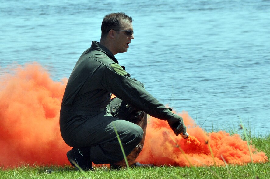 EGLIN AIR FORCE BASE, Fla. -- Staff Sgt. Benjamin Rosciglione, 33rd Operations Support Squadron, demonstrates the proper way to use a smoke flare during a Survival Evasion Resistance Escape training exercise for pilots June 26 at Post’l Point. The training was a water continuation course which included a parachute drag, raft living procedures and recovery hoist training. Pilots must undergo continuation training every three years. (Air Force photo by Airman Anthony Jennings) 