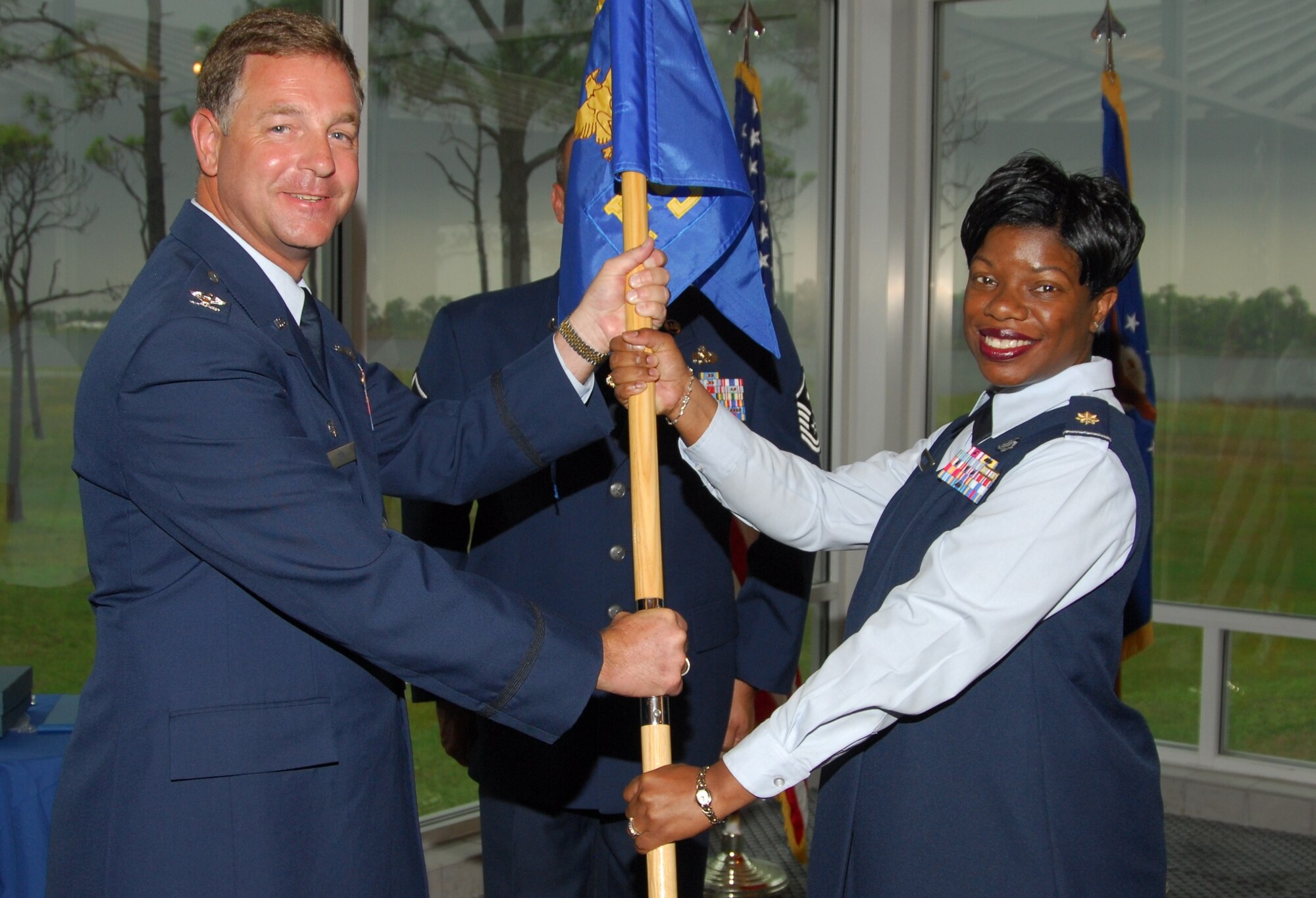 Col. David Zeh, 325th Mission Support Group commander, presents the guidon to Maj. Letitia Marsh as she takes command of the 325th Force Support Squadron.  The change of command ceremony took place June 29 at the Heritage Club.  Major Marsh took command over from Lt. Col. Michael Lamb.  (U.S. Air Force photo/Lisa Norman) 