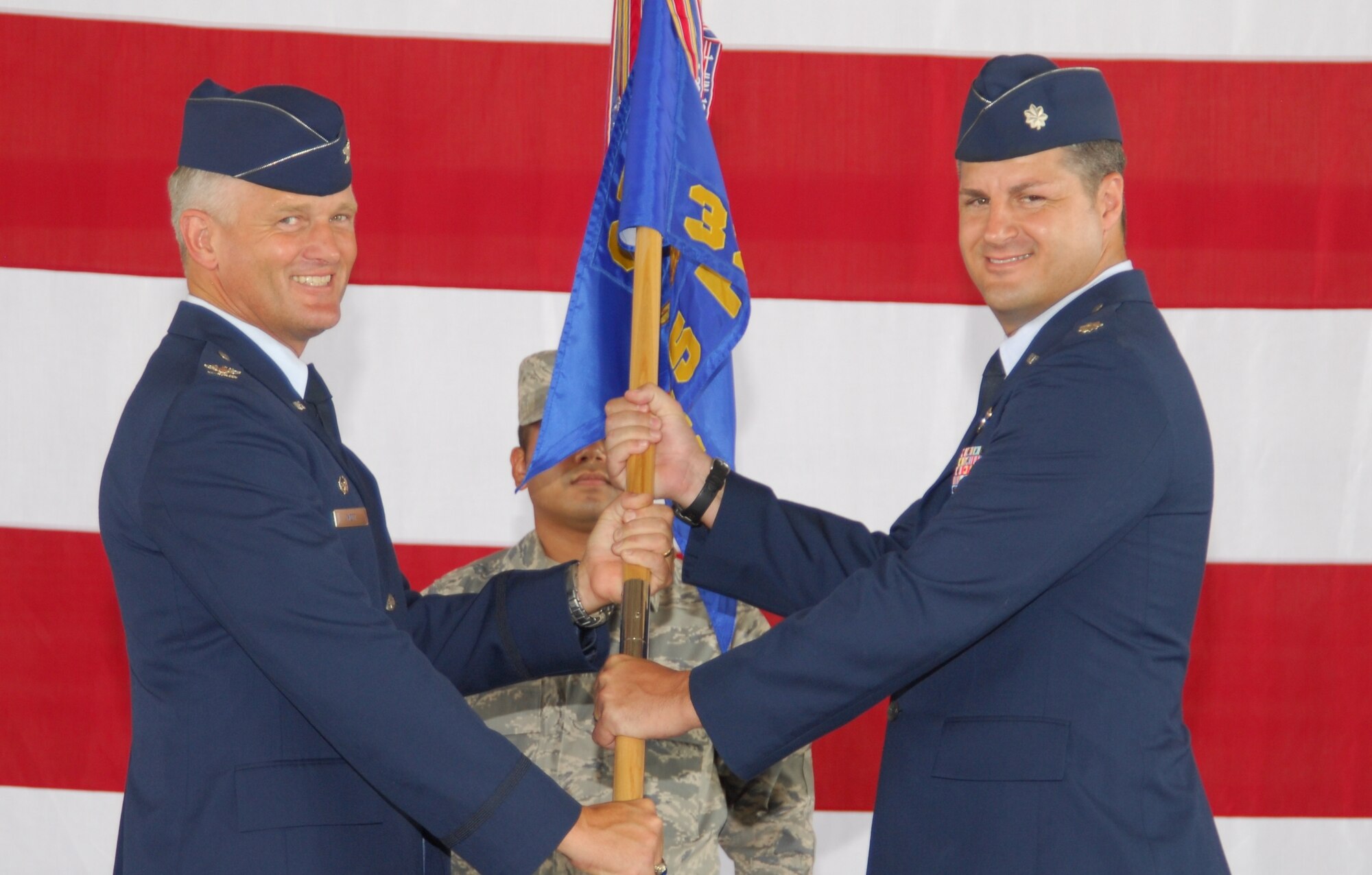 Col. William Mott, 325th Operations Group commander, presents the guidon to Lt. Col. Scott Yancy as he takes command of the 95th Fighter Squadron.  The change of command ceremony took place June 29 in Hangar 1.  Colonel Yancy took command over from Lt. Col. Kevin Huyck.  (U.S. Air Force photo/Lisa Norman) 