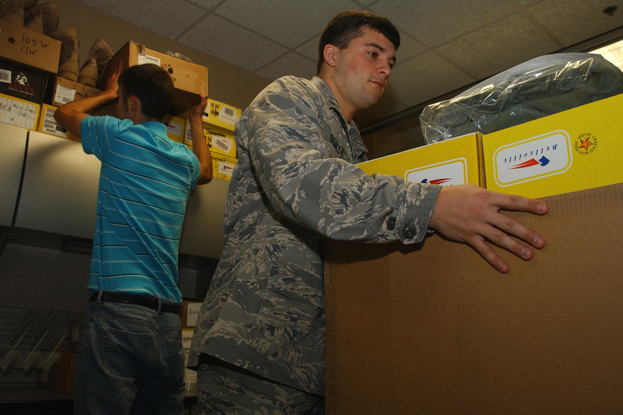 2nd Lt. Jeremiah Deibler, assigned to the wing deployment center while awaiting pilot training, and Nate Marshall, a summer hire, work to organize the supply room at the WDC. (U.S. Air Force photo by Staff Sgt. Brian Hill)