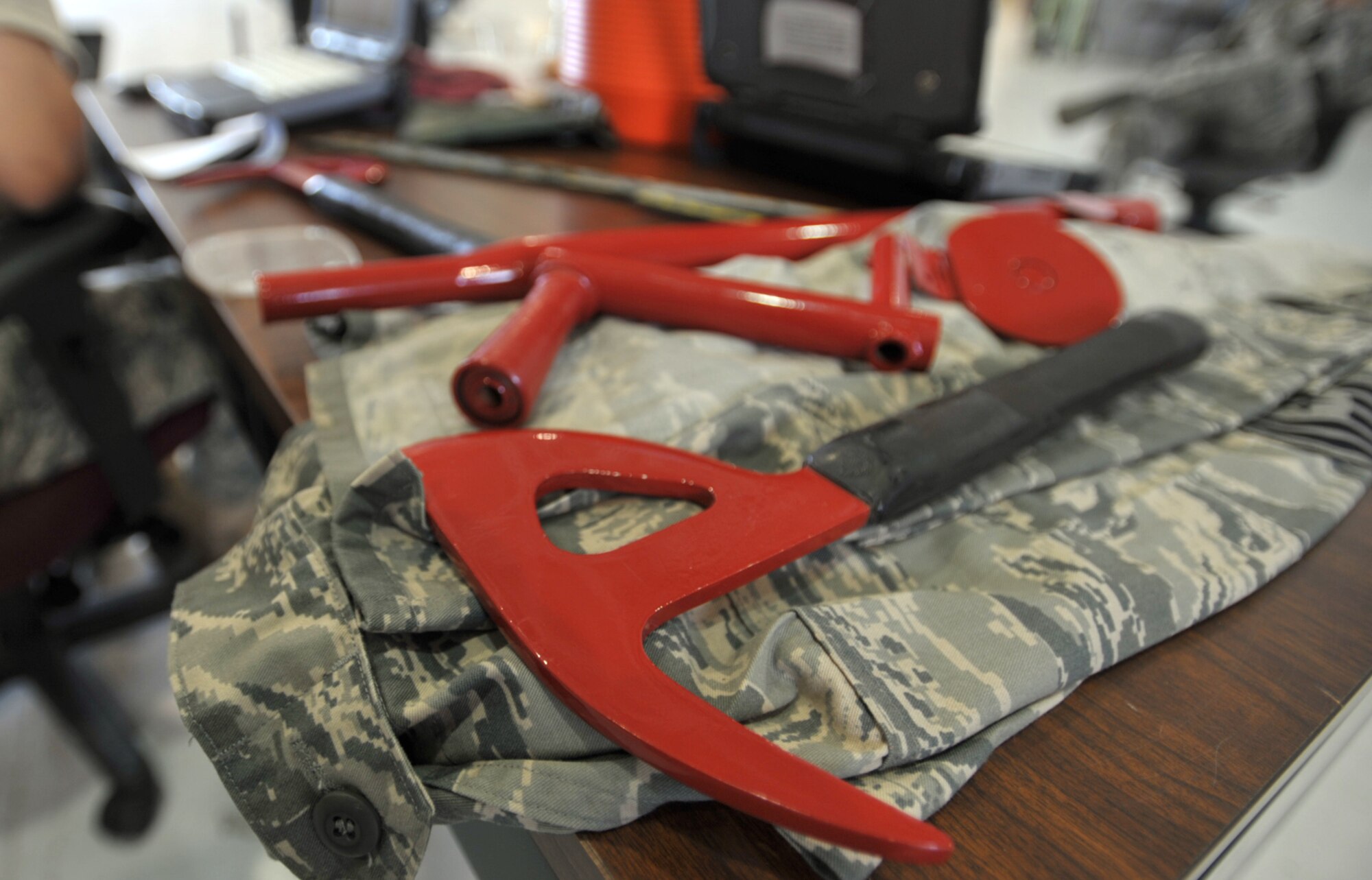 A painted and polished crash axe waits on a work table near a KC-135 Stratotanker scheduled to compete in Air Mobility Rodeo 2009. Cleaning and painting is part of the usual preparation for the biennial readiness competition. A crash axe can be used to cut through the wall of KC-135 in case of an emergency. (U.S. Air Force photo/Tech. Sgt. Jason Schaap) 