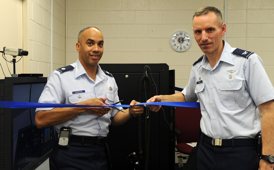 LANGLEY AIR FORCE BASE, Va. -- Lt. Col. Hans Augustus, 1st Fighter Wing vice commander, and Col. Eric Stone, 1st Medical Group commander, cut the ribbon to the Reduced Oxygen Breathing Device trainer at the Aerospace Physiology building June 29.  This is the first new hypoxia trainer in the Air Force in over 50 years.  (U.S. Air Force photo/Senior Airman Zachary Wolf)
