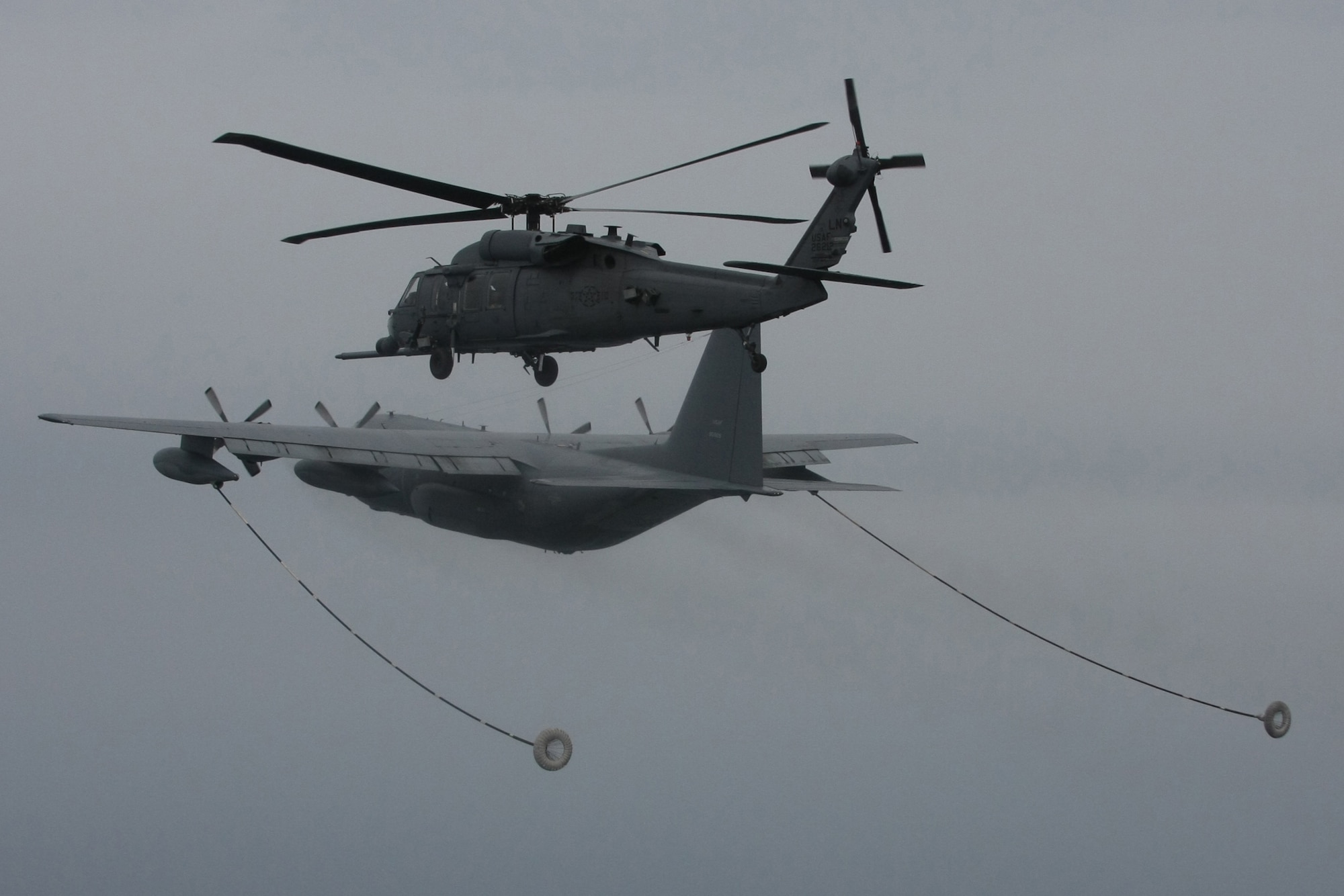 A HH-60G Pave Hawk helicopter from the 56th Rescue Squadron at RAF Lakenheath, England, prepares to be refueled from a MC-130P Combat Shadow during a rescue mission ov West coast of Ireland, June 26. The pararescue specialists and crew hoisted a sailor in need of emergent medical care onto their helicopter from the cargo ship, Pascha. The man was experiencing severe abdominal pain, requiring immediate medical evacuation. The MC-130 is from the 352nd Special Operations Group at RAF Mildenhall. A KC-135R Stratotanker from the 100th Air Refueling Wing from the same base, was also involved with the operation for refueling and communication purposes. A Nimrod, search and rescue aircraft, from the United Kingdom also played a critical role in the operation, providing real time communication and coordination between the ship and USAF aircraft. The patient was delivered to an awaiting ambulance in Shannon, Ireland, and is in stable condition. (U.S. Air Force photo/Master Sgt. Jay Reinschi.)