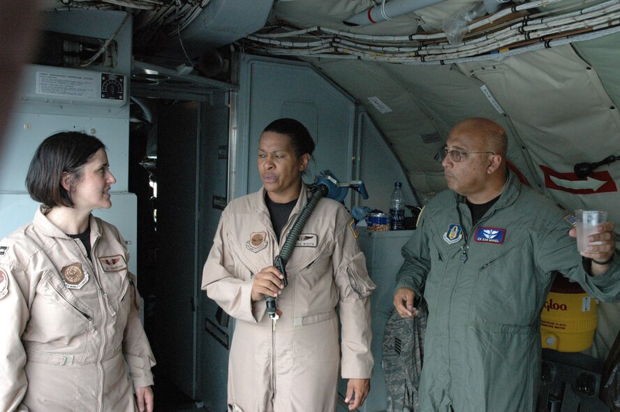 RAMSTEIN AIR BASE, GERMANY -- Lt. Col. Ed San Miguel, flight surgeon with the 916th Air Refueling Wing (right), talks with nurses Capt. Brenda White from Pope Air Force Base, N.C. and Capt. Robinson from McChord Air Force Base, Wash. (far left) These medical members are all part of an aeromedical evacuation mission from Ramstein to Bagram Air Base, Afghanistan. (U.S. Air Force photo courtesy of Ken Fine)