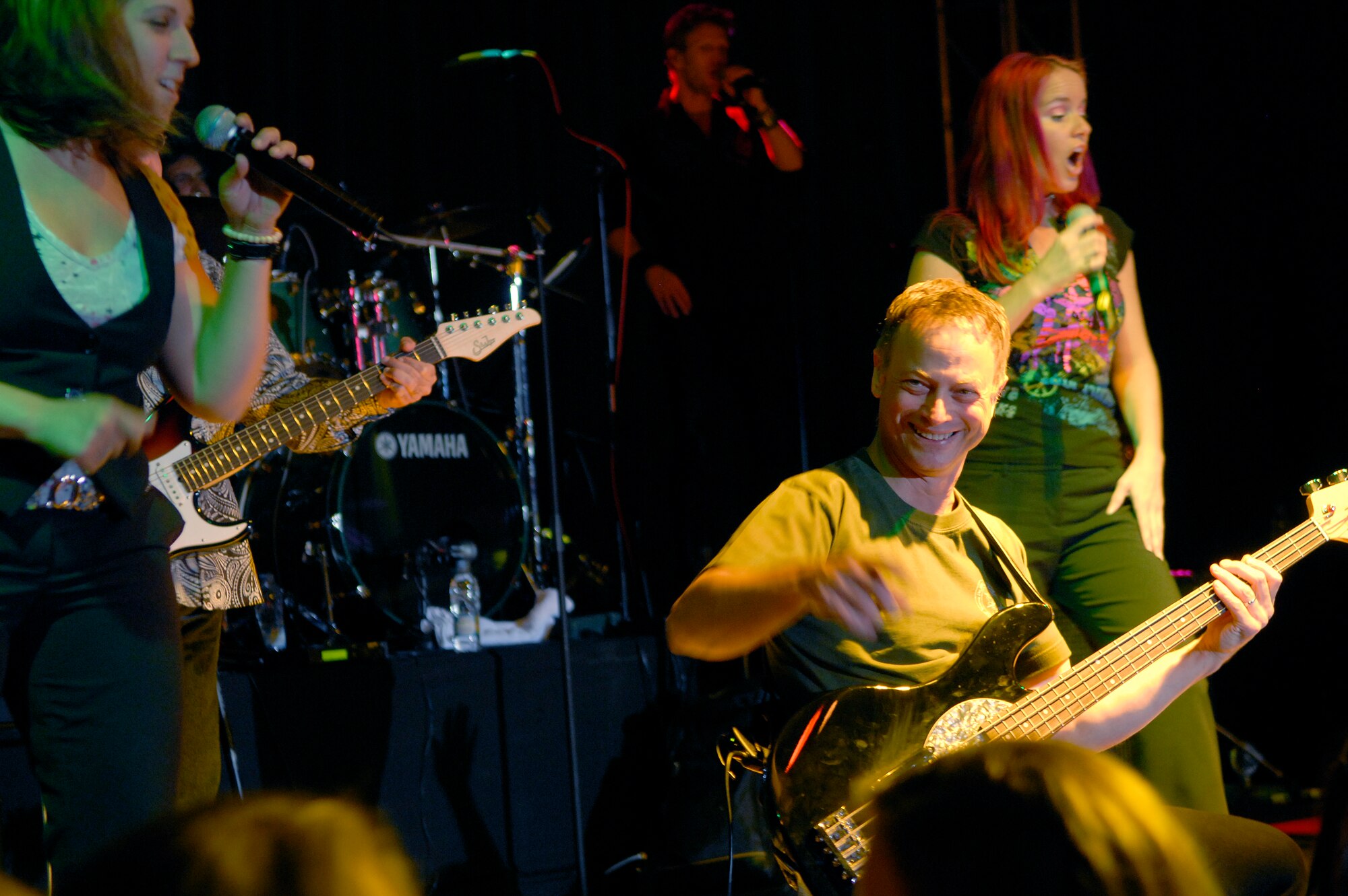 Gary Sinise of "The Lt. Dan Band" interacts with the audience as the band plays for a standing room only crowd, June 28, at the Osan Air Base, Republic of Korea, base theater. The band's mission is to do what it can to draw attention to military service members, their families and veterans and to make sure they know they are remembered and appreciated. (U.S. Air Force photo/Staff Sgt. Brian Ferguson)

