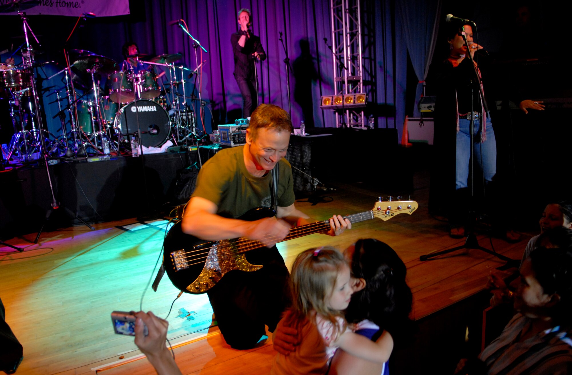 Gary Sinise of "The Lt. Dan Band" interacts with the audience as the band plays for a standing room only crowd, June 28, at the Osan Air Base, Republic of Korea, base theater. The band's mission is to do what it can to draw attention to military service members, their families and veterans and to make sure they know they are remembered and appreciated. (U.S. Air Force photo/Staff Sgt. Brian Ferguson)



