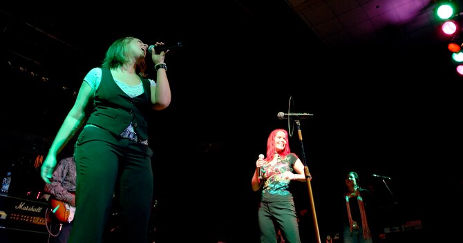 Vocalists (left) Gina Gonzalez and Julie Dutchak of "The Lt. Dan Band" sing for a standing room only crowd, June 28, at the Osan Air Base, Republic of Korea, base theater. The band's mission is to do what it can to draw attention to military service members, their families and veterans and to make sure they know they are remembered and appreciated. (U.S. Air Force photo/Staff Sgt. Brian Ferguson)