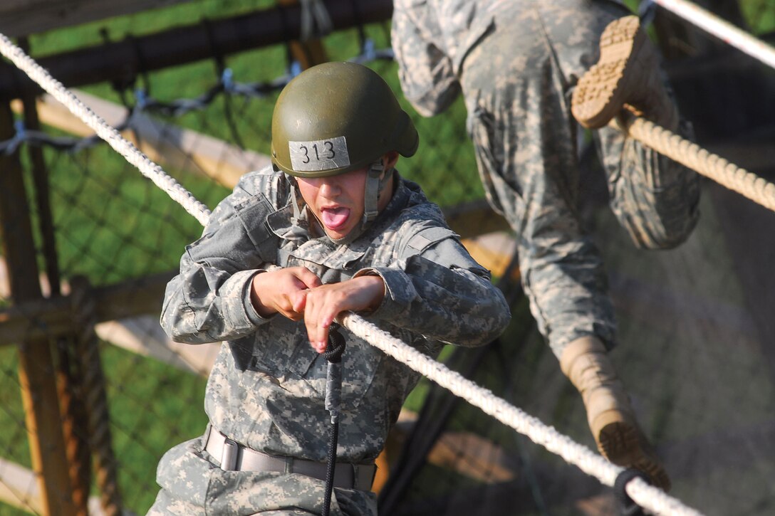 U.S. Army Pvt. Jonathan Fishbeck concentrates on crossing a two-rope bridge during Eagle Tower exercises on Fort Benning, Ga,, June 16, 2009. The two-rope bridge consists of one rope to walk on and one rope located at chest level for balance.