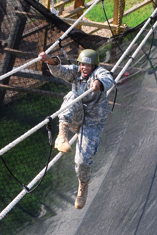 U.S. Army Pvt. William Reynolds struggles with the three-rope bridge during Eagle Tower exercises on Fort Benning, Ga., June 16, 2009. Safety netting below the bridge crossing is designed to catch anyone who falls off the ropes during the event.