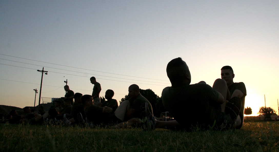 Headquarters and Headquarters Squadron Marines pump out their crunches during a physical fitness test at the Marine Corps Air Station in Yuma, Ariz., June 30, 2009. Active duty Marines are required to run two PFTs annually, one before June 30 and one before Dec. 31.