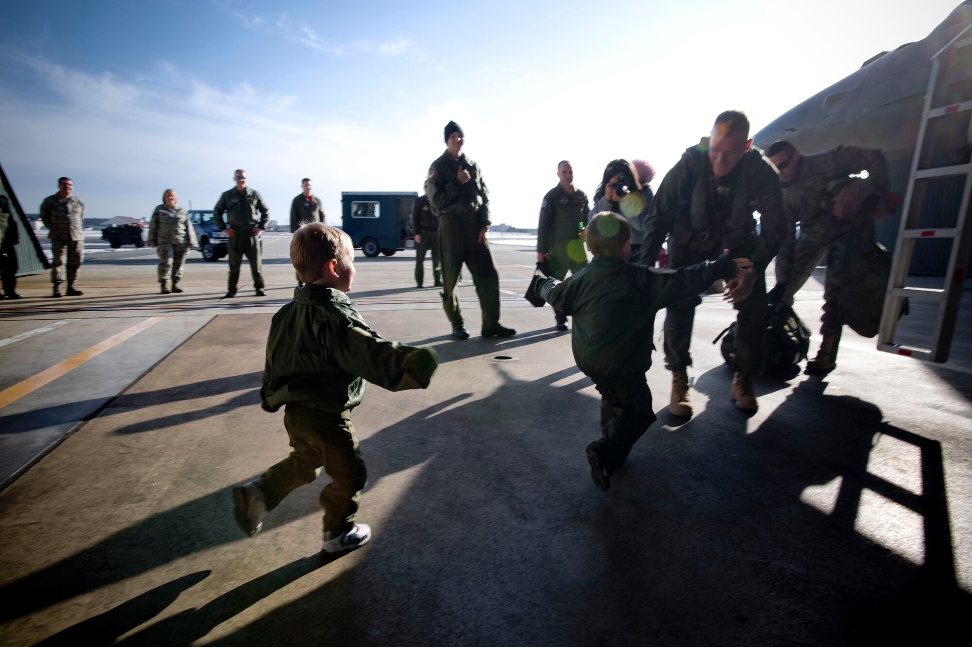 MISAWA AIR BASE, Japan -- Twin boys run to their father, Capt. Michael Fisher, flight commander, 14th Fighter Squadron, Feb. 27, 2009. Captain Fisher, along with his squadron, returned from a deployment to Joint Base Balad, Iraq. (U.S. Air Force photo by Staff Sgt. Samuel Morse)