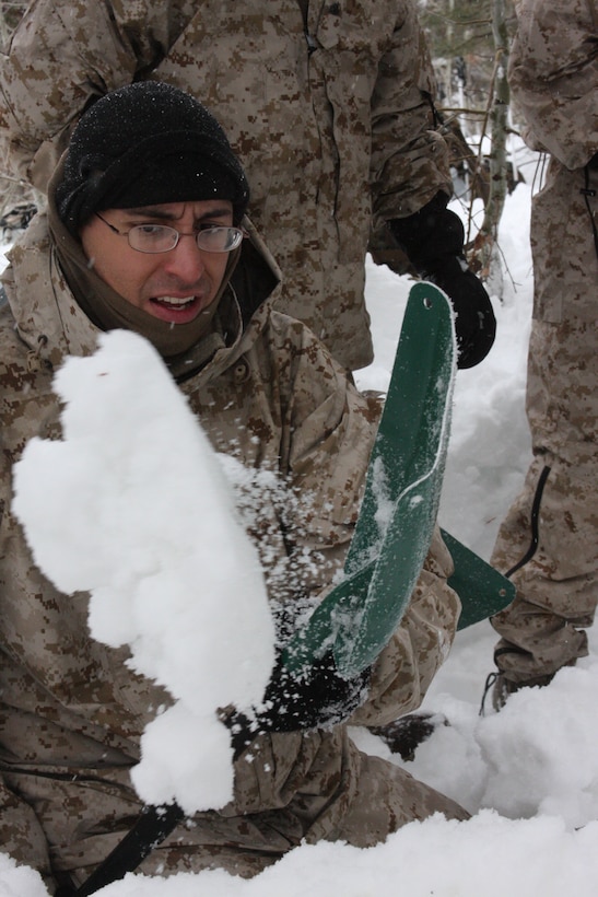 Seaman Michael J. Arroyo, a corpsman with Regimental Combat Team 7, flicks a shovel full of snow off to the side of his bivouac, or camp area, during the Mountain Warrior Exercise training package at Marine Corps Mountain Warfare Training Center Bridgeport, Calif., March 2.