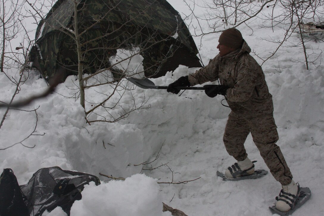 Cpl. Isidro Cobos, a warehouse clerk with Regimental Combat Team 7, clears an area for his bivouac, or camp area, while participating in the Mountain Warrior Exercise in training area Aspen Bowl at Marine Corps Mountain Warfare Training Center Bridgeport, Calif., March 2.