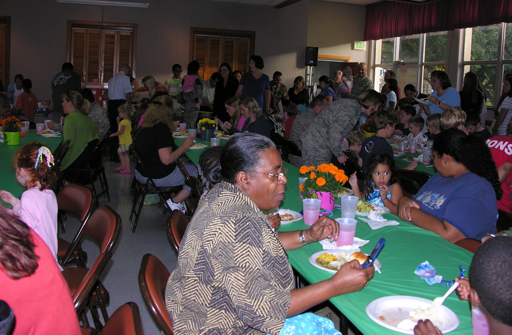 Nearly hundreds of family members with deployed spouses enjoy a meal that was provided by 15th Airlift Wing Chapel Traditional Service volunteers on Thursday, 26 Feb, at the Nelles Chapel Multipurpose Room.  (U.S. Air Force photo/Jackie Hites)