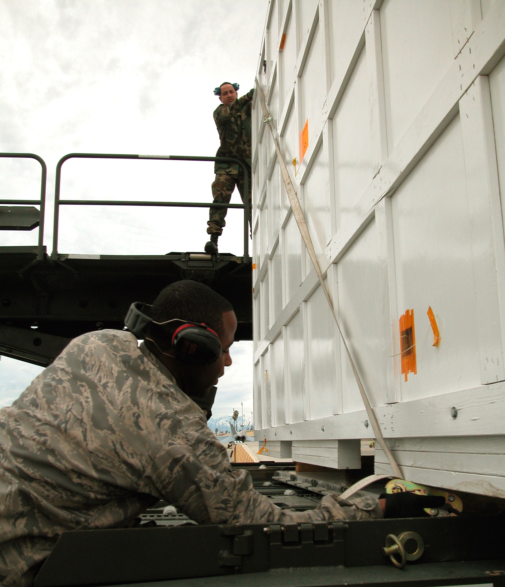 Technical Sgt. Kenneth Brooks, an Air Transportation Specialist with the 56th Aerial Port Squadron, and Airman Jaron Buchanan, an Air Transportation Specialist with the 50th Aerial Port Squadron, secure NASA’s newest Mars exploration vehicle to a 60K loader so it can be loaded into a C-17. March ARB personnel are working with NASA’s Jet Propulsion Laboratory to get the spacecraft its Air Certification so it can be transported to Cape Canaveral, Fla. It is scheduled to launch in 2011 to assess whether Mars was, or still is, an environment able to support microbial life, according to NASA’s Jet Propulsion Laboratory’s website. (Air Force photo by Senior Airman  David Flaherty)