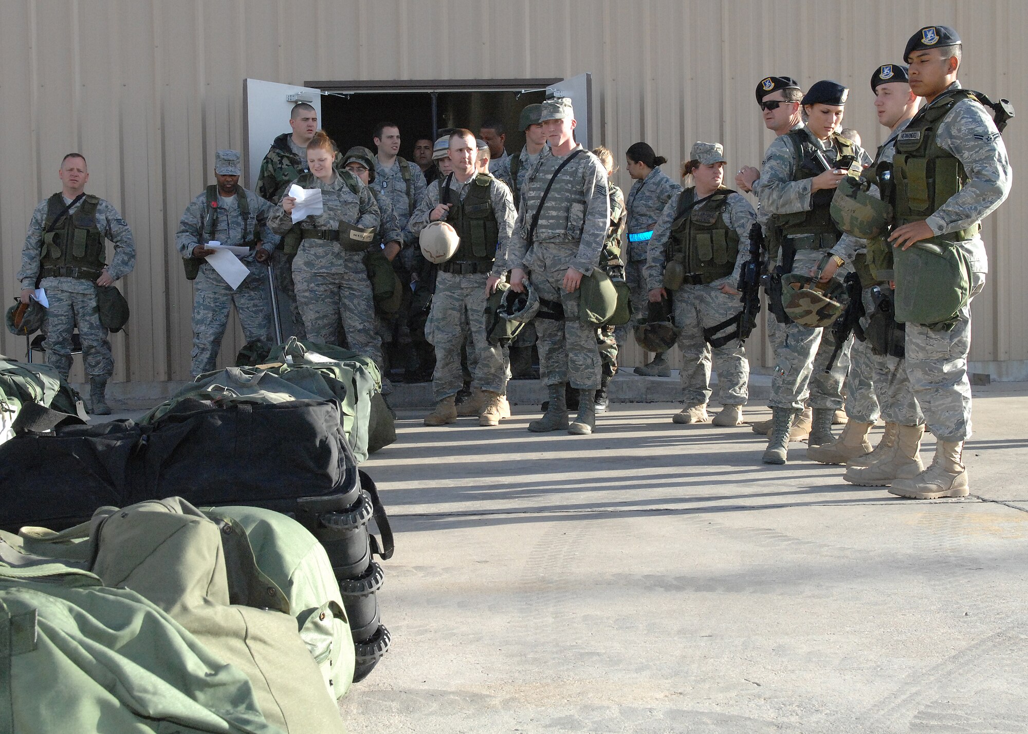 Airmen from the 49th Fighter Wing wait to pick up their mobility bags outside the deployment control center on Holloman Air Base, N.M., Feb. 25, 2009, as part of a Phase I Exercise. A Phase I tests the wing's ability to mobilize and deploy as quickly as possible. (U.S Air Force photo/Senior Airman Russell Scalf)
