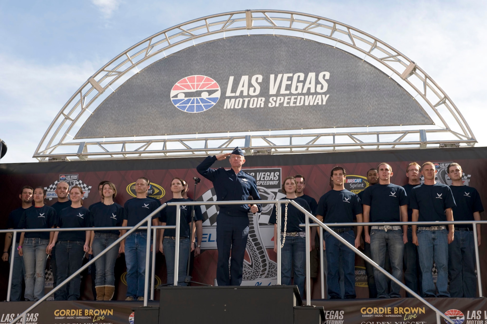 Lt. Gen. Ronald F. Sams salutes race fans attending the Shelby 427 race after administering the oath of enlistment to 19 Air Force recruits March 1 at Las Vegas Motor Speedway in Nevada. The recruits are part of the delayed enlistment program from the Las Vegas area. General Sams is the Air Force inspector general. (U.S. Air Force photo/Master Sgt. Jack Braden)