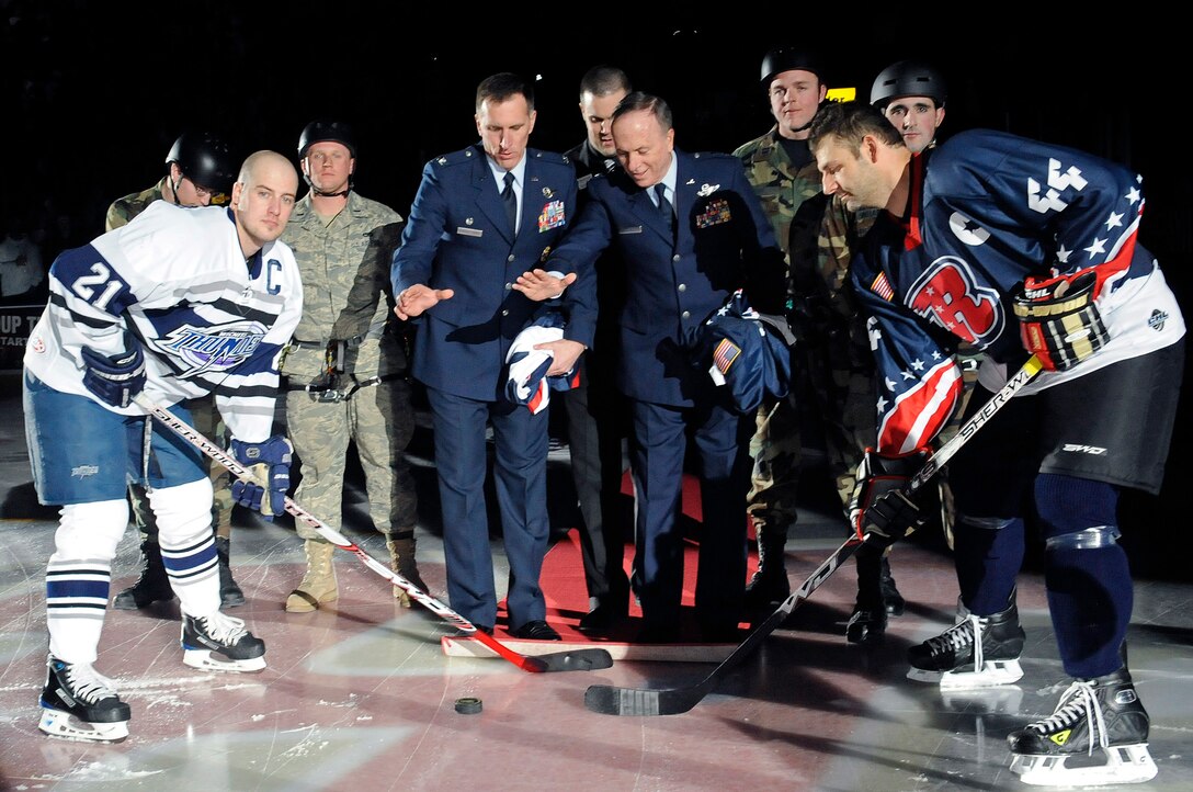 (Center Left to Right) Col. Scott Vander Hamm, 28th Bomb Wing Commander, and Maj. Gen. Steven Doohen, South Dakota National Guard adjutant general, drop the ceremonial first pucks to begin a hockey game between the Rapid City Rush and Wichita Thunder at the Rushmore Plaza Civic Center Feb. 28. More than 5,000 fans attended the Military Appreciation Night hockey game. (US Air Force photo/Airman 1st Class Corey Hook)