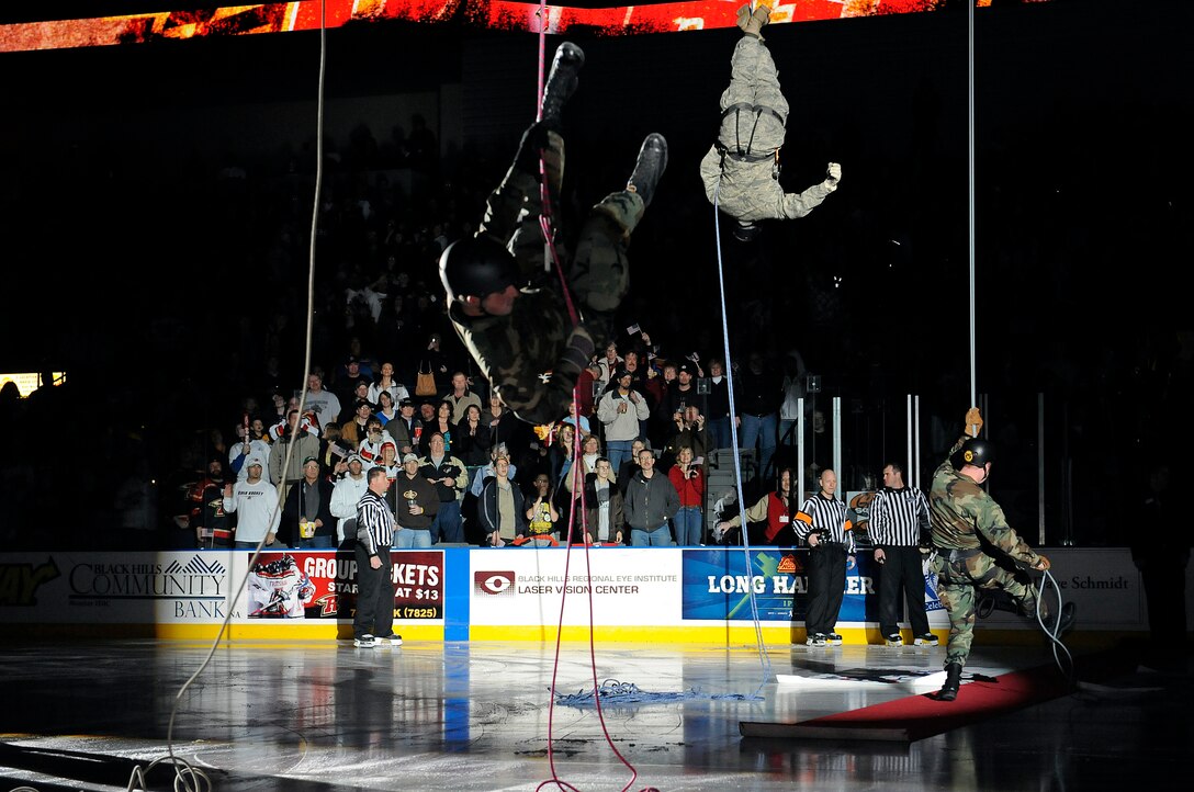 Company grade officers from Ellsworth repel onto the ice from the rafters at a Rapid City Rush game at the Rushmore Plaza Civic Center Feb. 28. More than 5,000 fans attended the Military Appreciation Night hockey game. (US Air Force photo/Airman 1st Class Corey Hook)