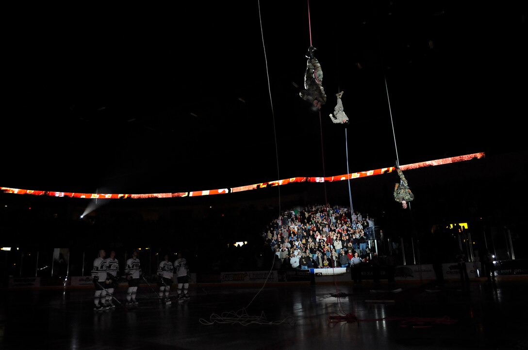 Company grade officers from Ellsworth repel onto the ice from the rafters at a Rapid City Rush game at the Rushmore Plaza Civic Center Feb. 28. The Wichita Thunder defeated the Rush 3-2 during Military Appreciation Night honoring past and present servicemembers. (US Air Force photo/Airman 1st Class Corey Hook)