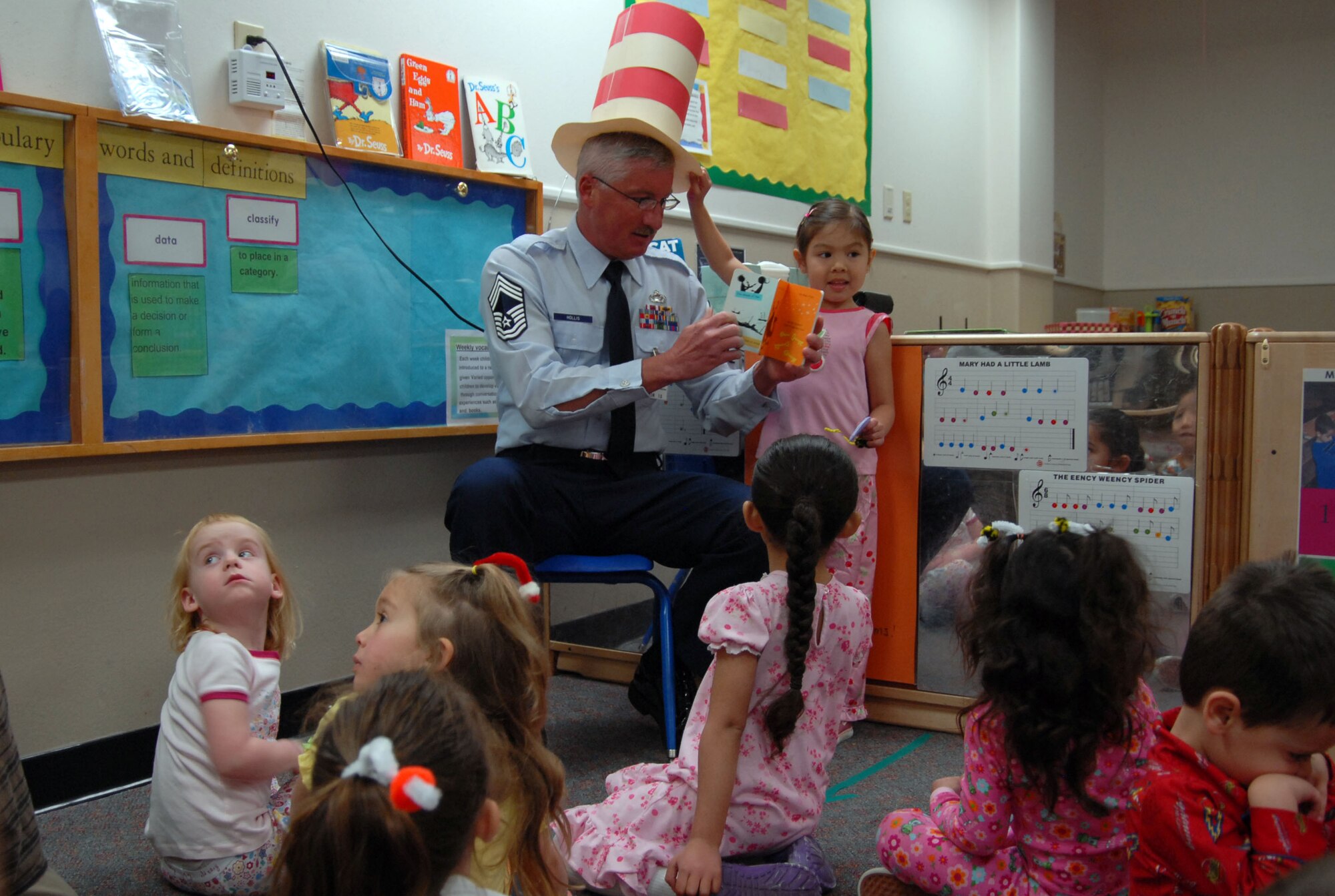 Chief Master Sgt. Andrew Hollis, 95th Mission Support Group superintendent, reads a book to children with the Child Development Center here March 2 as part of Read Across America. Read Across America is recognized each year in March to commemorate the birthday of author Theodore Geisel, better known by his pen name, Dr. Seuss. This event is also an opportunity for servicemembers to interact with children and instill in them the importance of reading. (Air Force photo by Senior Airman Julius Delos Reyes)
