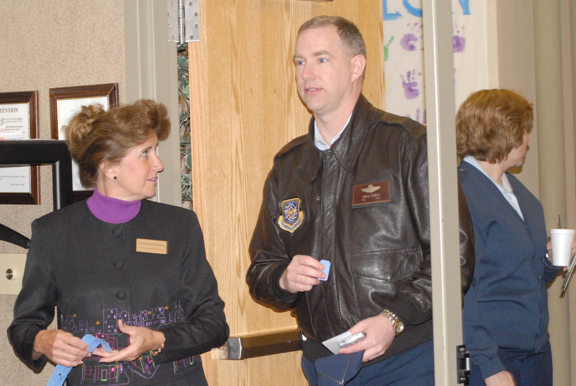 Ms. Georgianne Kiggins, 43rd Security Forces Squadron, hands a raffle ticket to Col. John Gordy, 43rd Airlift Wing Vice Commander, prior to the kickoff of Military Saves Week here Feb. 23. (U.S. Air Force Photo by Airman 1st Class Mindy Bloem)