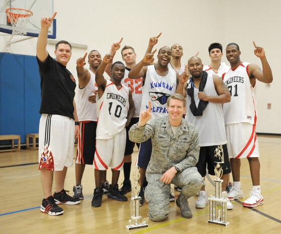 NELLIS AIR FORCE BASE, Nev. -- The 99th Civil Engineering Squadron poses for a group shot with their commander, Lt. Col. Markus Henneke, after winning the championship game of the 2009 Nellis Fitness Intramural Basketball Tournament Feb. 27. CES beat MDG to become the 2009 intramural basketball champions.(U.S. Air Force photo by Aiman 1st Class Bret Clashman)