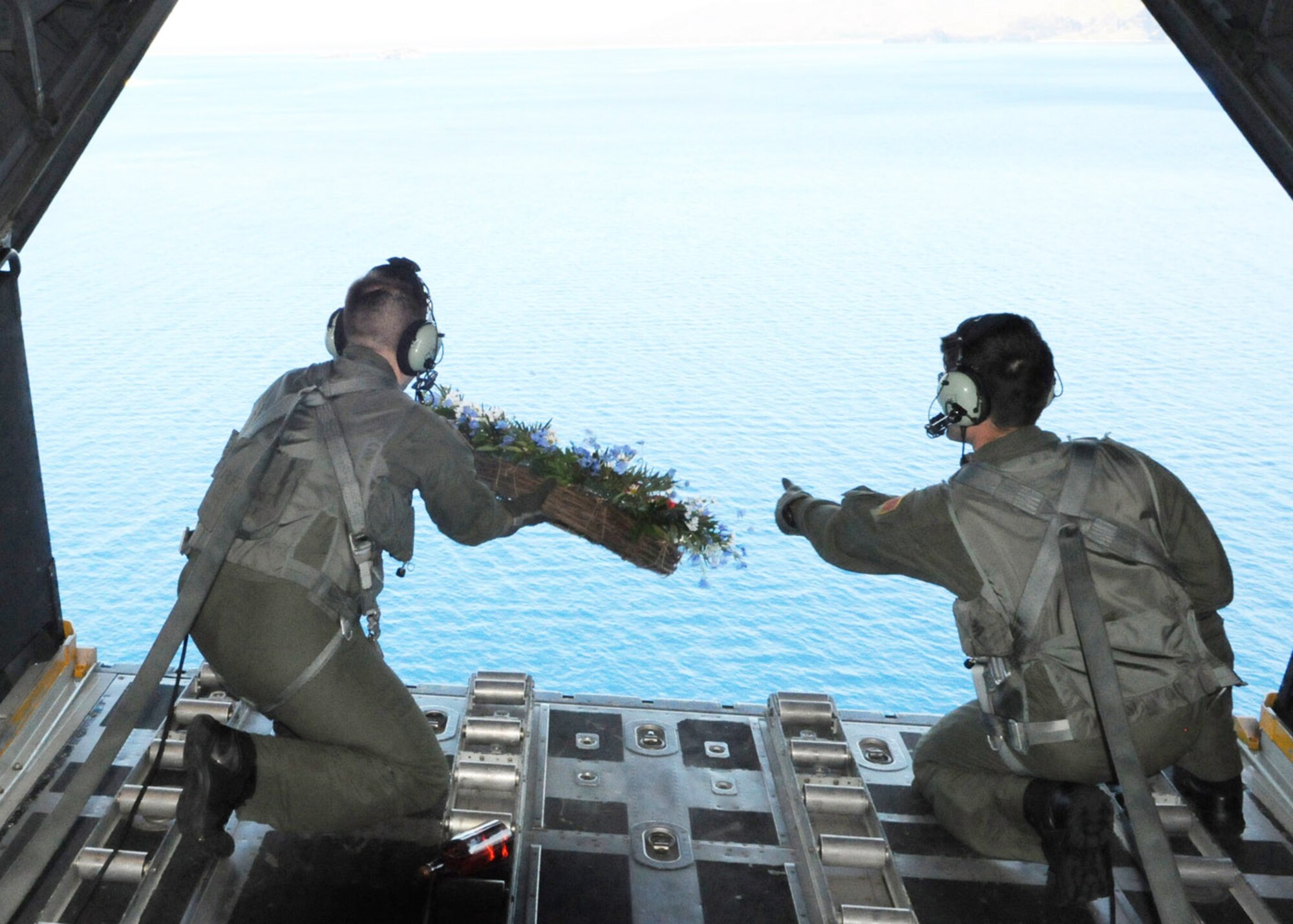 Staff Sgts. Nicholas Adams (left) and Steve Pressler release a memorial wreath out the back of a MC-130H Combat Talon II Feb. 26 to honor fallen brethren that were lost 28 years ago near Capones Island, Philippines. A 1st Special Operations Squadron MC-130E, call sign Stray 59, crashed during an exercise killing eight crewmembers and 15 passengers and a crew from Kadena Air Base, Japan, flew to reach the exact coordinates of the crash site to release the ceremonial wreath. The memorial flight has been flown every year since the accident in 1981. Sergeants Adams and Pressler are 1st SOS loadmasters. (U.S. Air Force photo/Tech. Sgt. Aaron Cram) 
