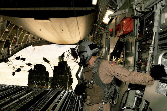 Senior Airman Rory Nowosielski stands on the ramp as container delivery system bundles exit the aircraft during a high-altitude airdrop mission in a C-17 Globemaster III Feb. 14 over Afghanistan. Airman Nowosielski is a C-17 loadmaster with the 816th Expeditionary Airlift Squadron. (U.S. Air Force photo/Staff Sgt. James L. Harper Jr.)
