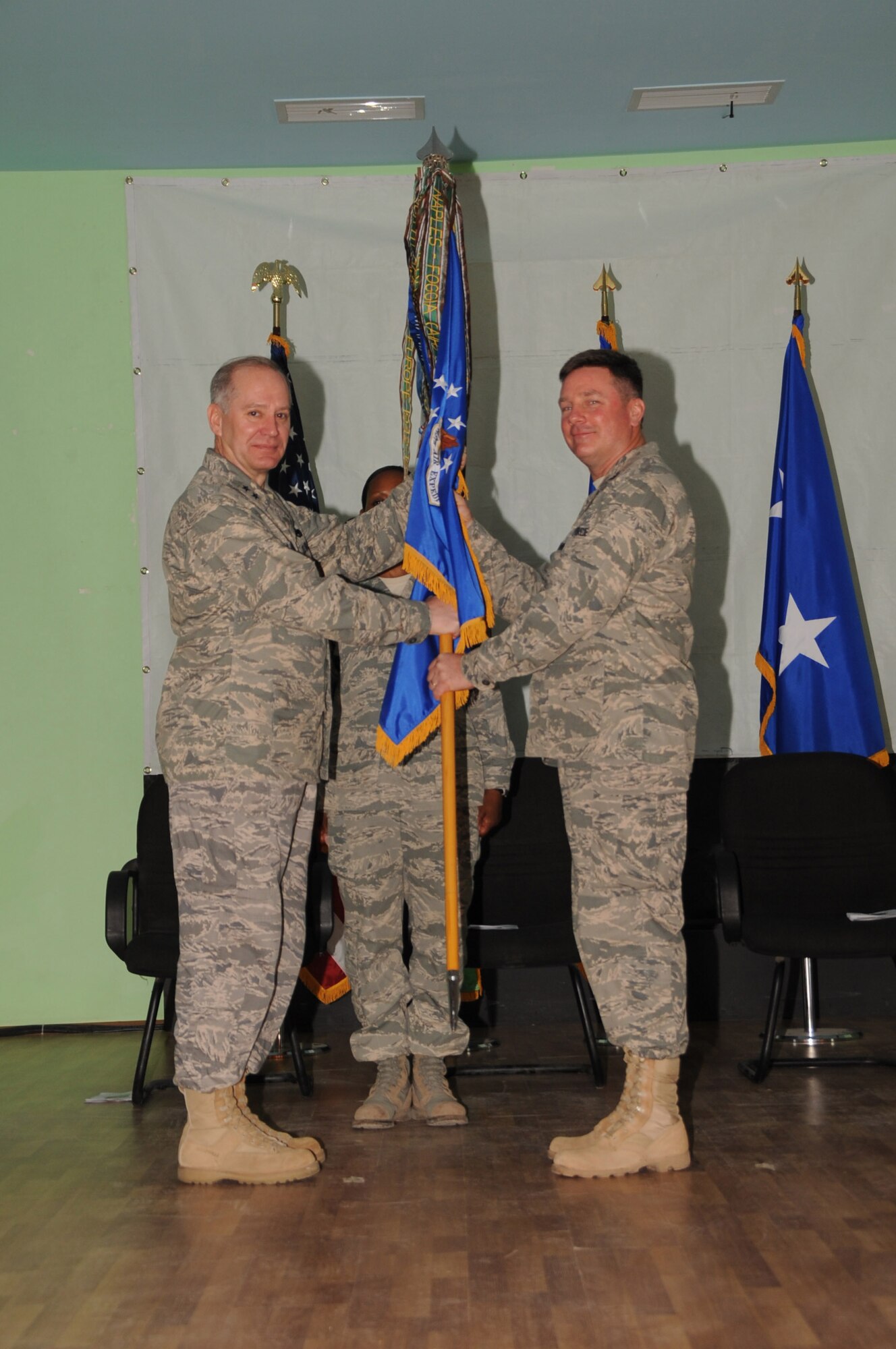 Seventeenth Air Force Commander Maj. Gen. Ronald Ladnier transfers the squadron flag to Col. John Brunhaver, the incoming commander of the 449 Air Expeditionary Group, during a change of command ceremony at Camp Lemonier, Djibouti, Feb. 27. The mission of the 449 AEG is to provide air support and superiority in the Horn of Africa (Photo by Navy MCC(SW) James M. Drake)