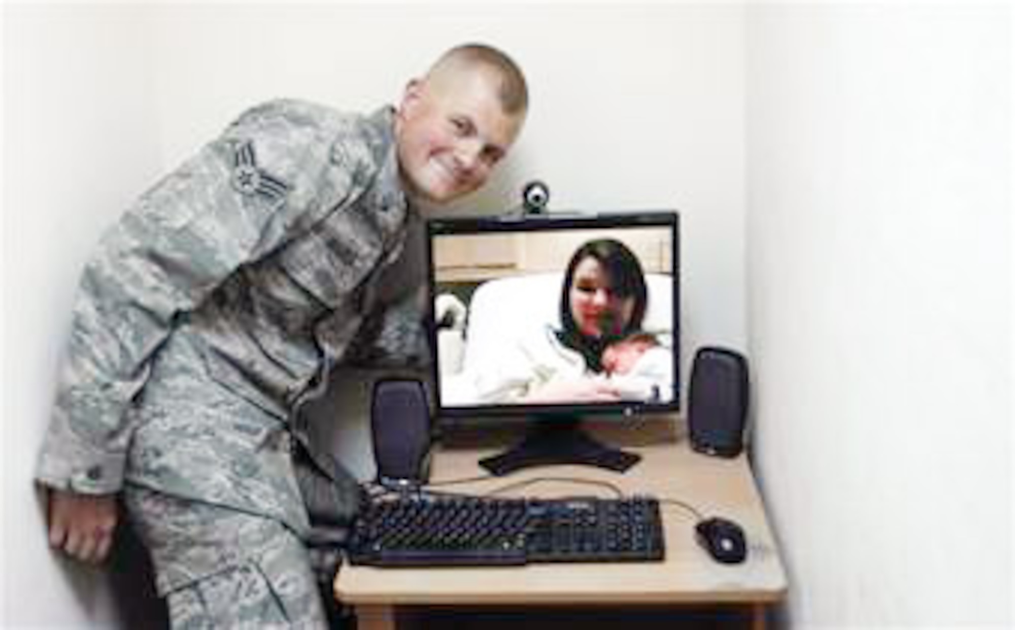 Senior Airman Daniel Warila poses for his first family portrait with his wife, Skye, and their newborn son, Lucas, Feb. 19 from an air base in Southwest Asia. Airman Warilla was able to watch Lucas' birth live. Airman Warila is a 380th Expeditionary Maintenance Squadron aerospace ground equipment mechanic. (U.S. Air Force photo/Staff Sgt. Mike Andriacco) 
