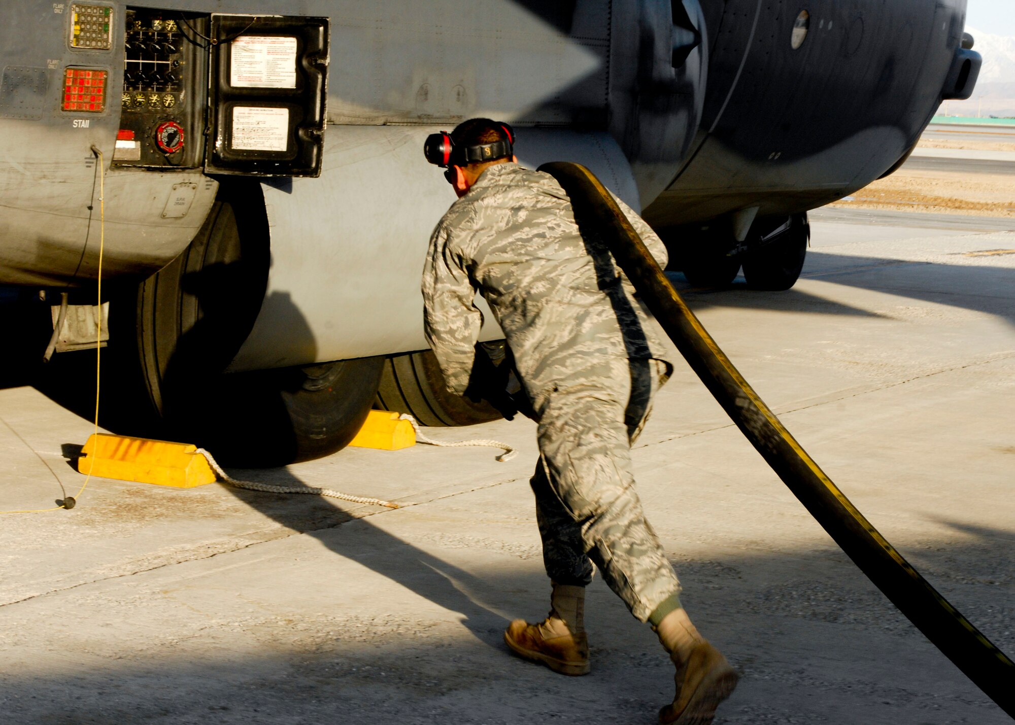 Airman 1st Class Jimmy Farias, 455th Expeditionary Logistics Readiness Squadron, runs the hose to a MC-130, Combat Talin 1 to refuel at Bagram Air Field, Afghanistan, Feb. 27. Airman Farias arrived to BAF on Jan 4., within 52 days on station he set the record for issuing 1,001,978 gallons of aviation fuel to 428 US and coalition aircraft. The previous record was 56 days. Airman Farias is deployed from Elmendorf Air Force Base, Alaska and hales from Dallas, Texas.(U.S. Air Force photo/ Senior Airman Erik Cardenas)(Released)