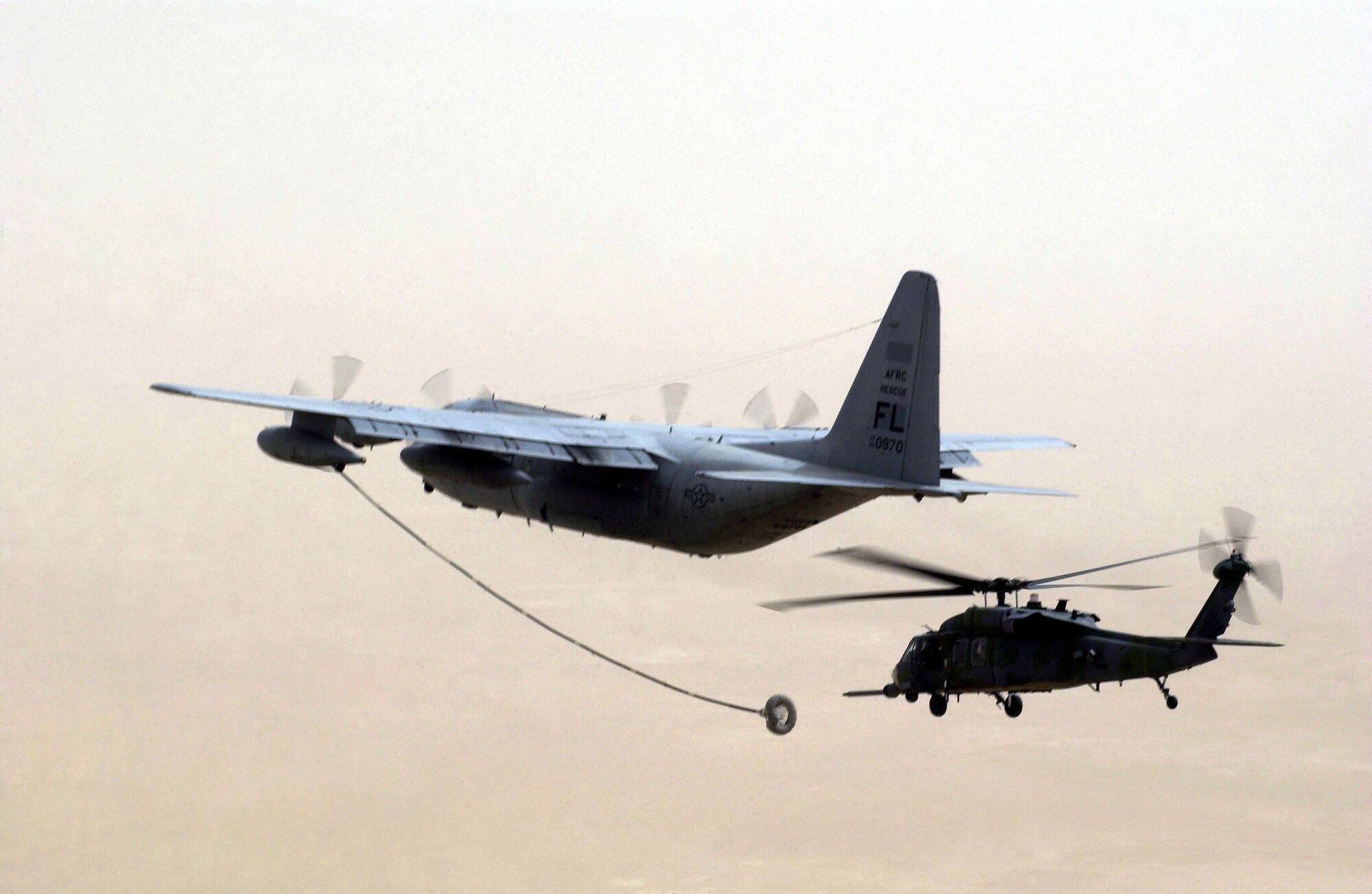 An HH-60G Pave Hawk helicopter approaches the refueling drogue of a US Air Force Reserve (USAFR) Command HC-130P/N long-range refueling Hercules aircraft.
