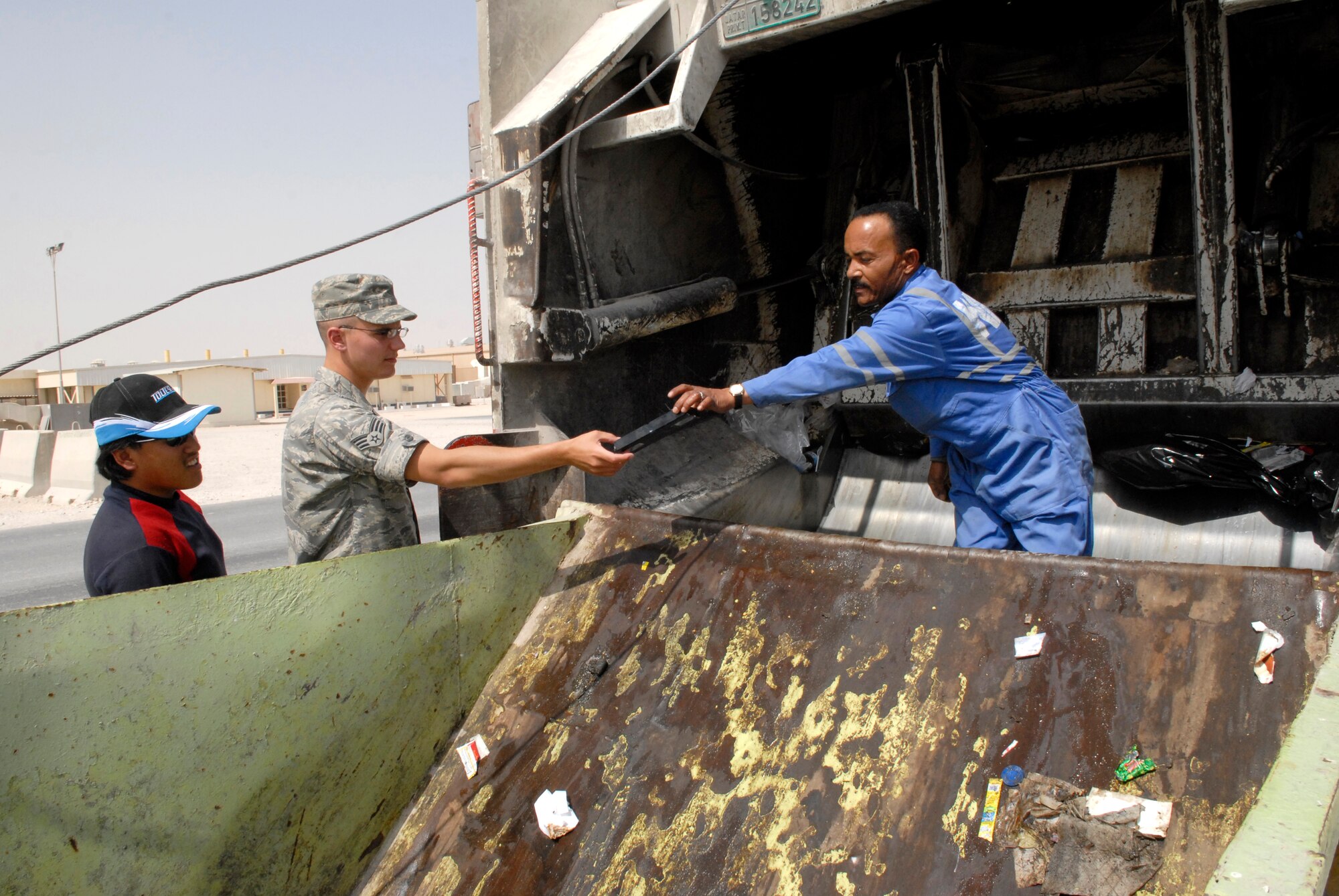 Senior Airman Thaddeus Kloss, a 379th Expeditionary Civil Engineer Squadron Third Country National Escort, checks and collects items that look sensitive in nature during a trash pickup, Feb. 26, 2009, at an undisclosed location in Southwest Asia.  Airman Kloss performs an over-watch of off-base contract workers ensuring the security of the area and the safety of service members on the base.  Airman Kloss hails from Brunswick, Maine and is deployed from Spangdahlem Air Base, Germany in support of Operations Iraqi and Enduring Freedom and Combined Joint Task Force - Horn of Africa.  (U.S. Air Force Photo by Airman 1st Class Andrew Satran/Released)