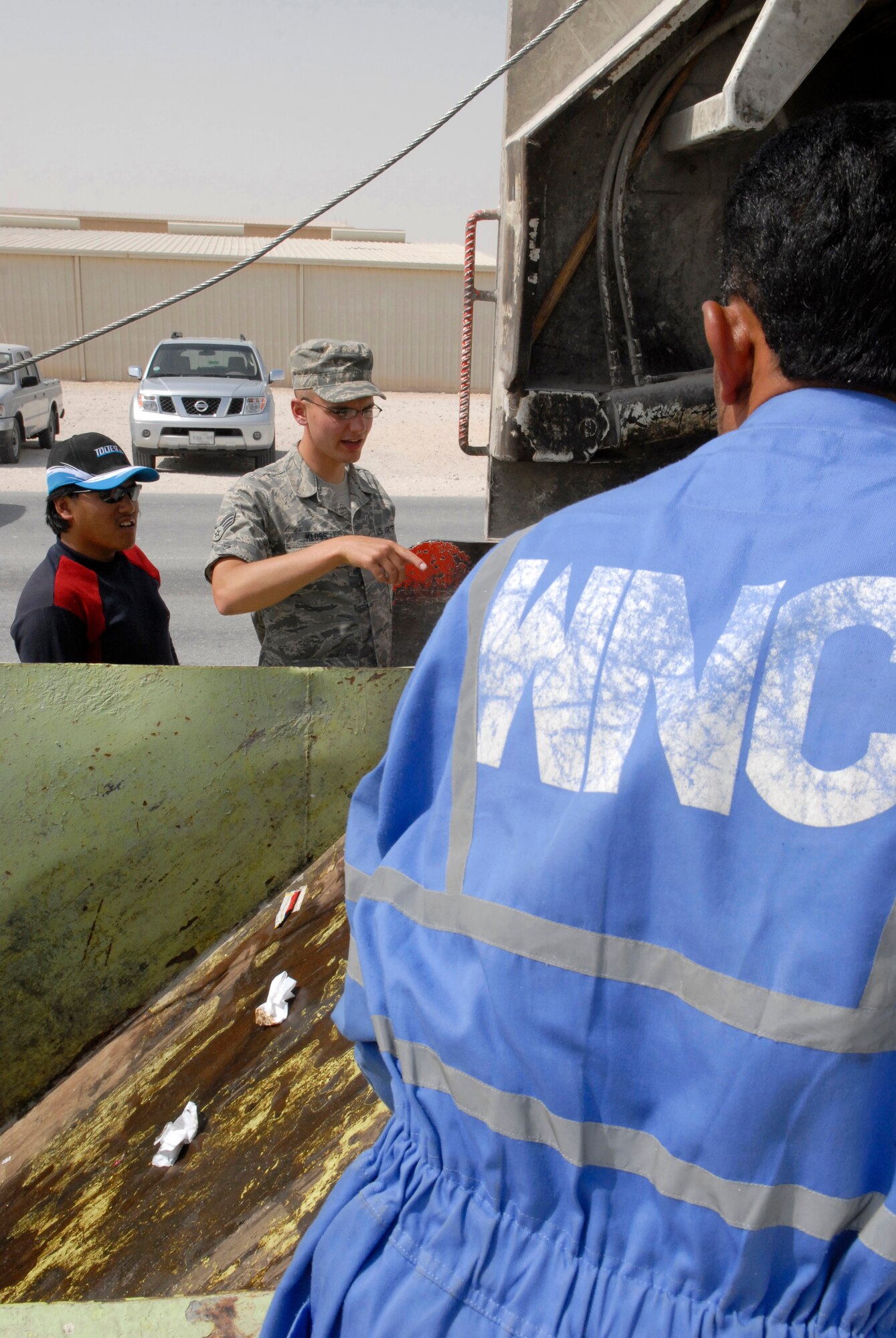 Senior Airman Thaddeus Kloss, a 379th Expeditionary Civil Engineer Squadron Third Country National Escort, checks the trash collection for sensitive materials, Feb. 26, 2009, at an undisclosed location in Southwest Asia.  Airman Kloss performs an over-watch of off-base contract workers ensuring the security of the area and the safety of service members on the base.  Airman Kloss hails from Brunswick, Maine and is deployed from Spangdahlem Air Base, Germany in support of Operations Iraqi and Enduring Freedom and Combined Joint Task Force - Horn of Africa.  (U.S. Air Force Photo by Airman 1st Class Andrew Satran/Released)